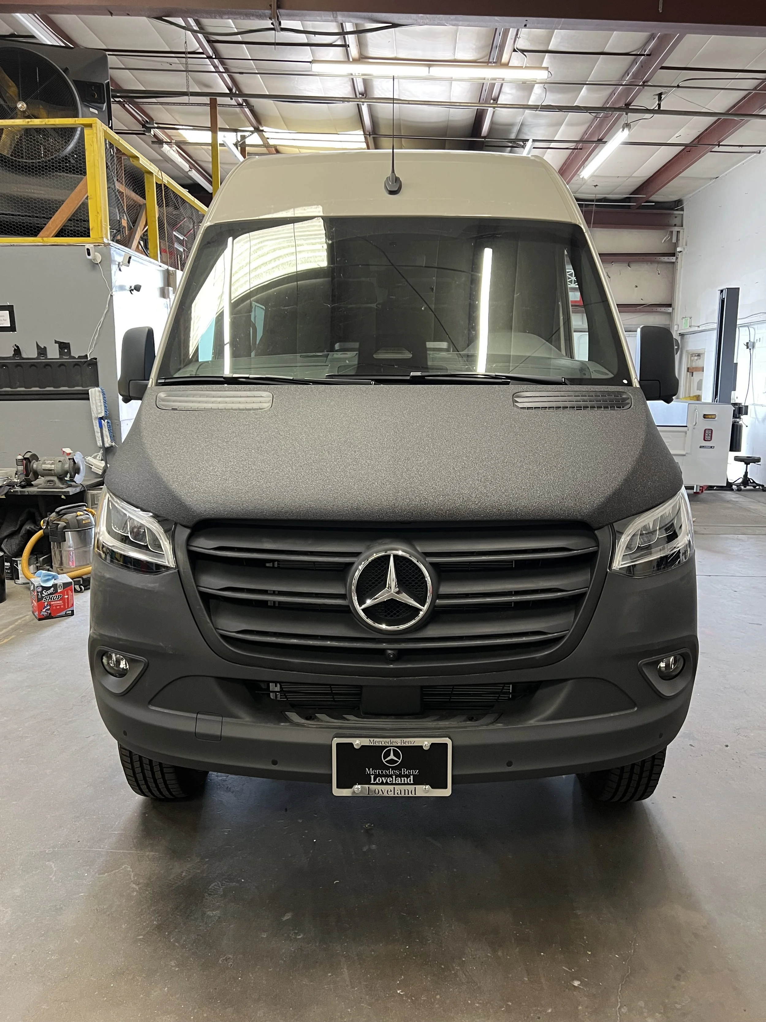 Front view of a Mercedes-Benz van inside a warehouse with a license plate reading 'Loveland'.