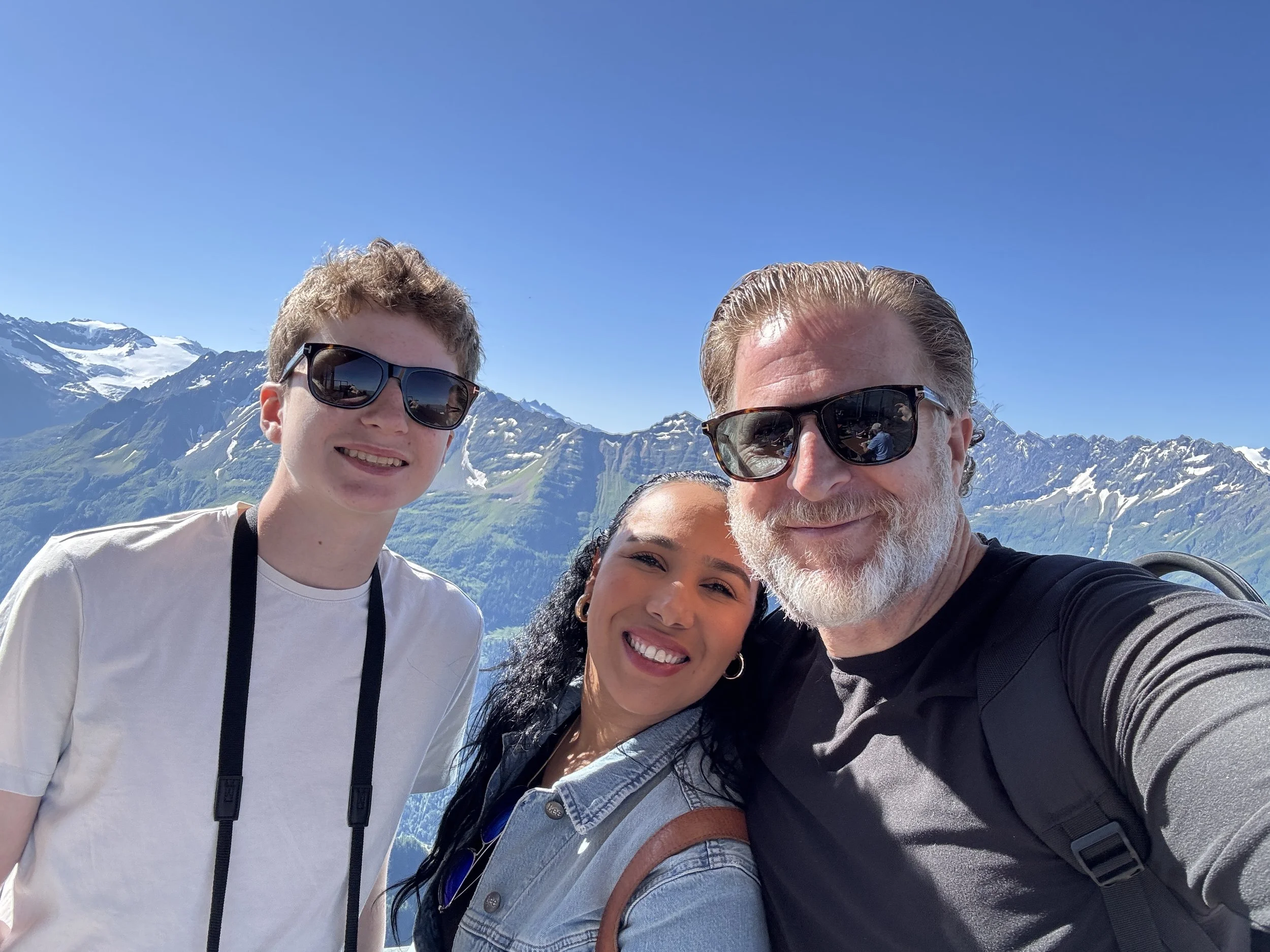 A photo of my son, my wife, and I on top of a mountain in Switzerland.