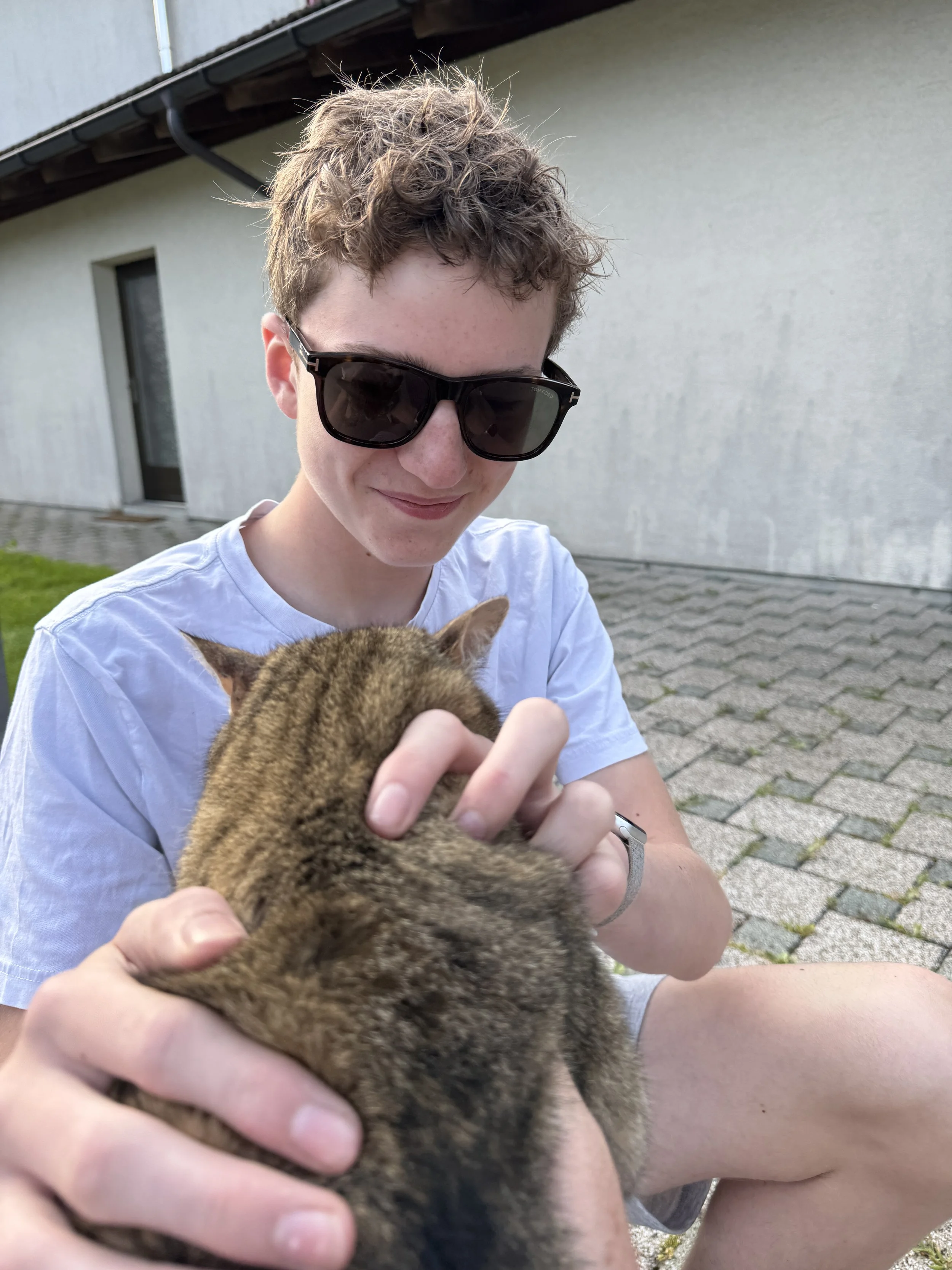 My son petting a random cat in Switzerland.