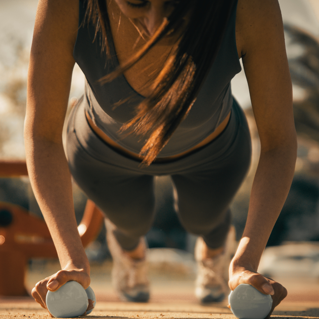 Women doing pushups with dumbbells
