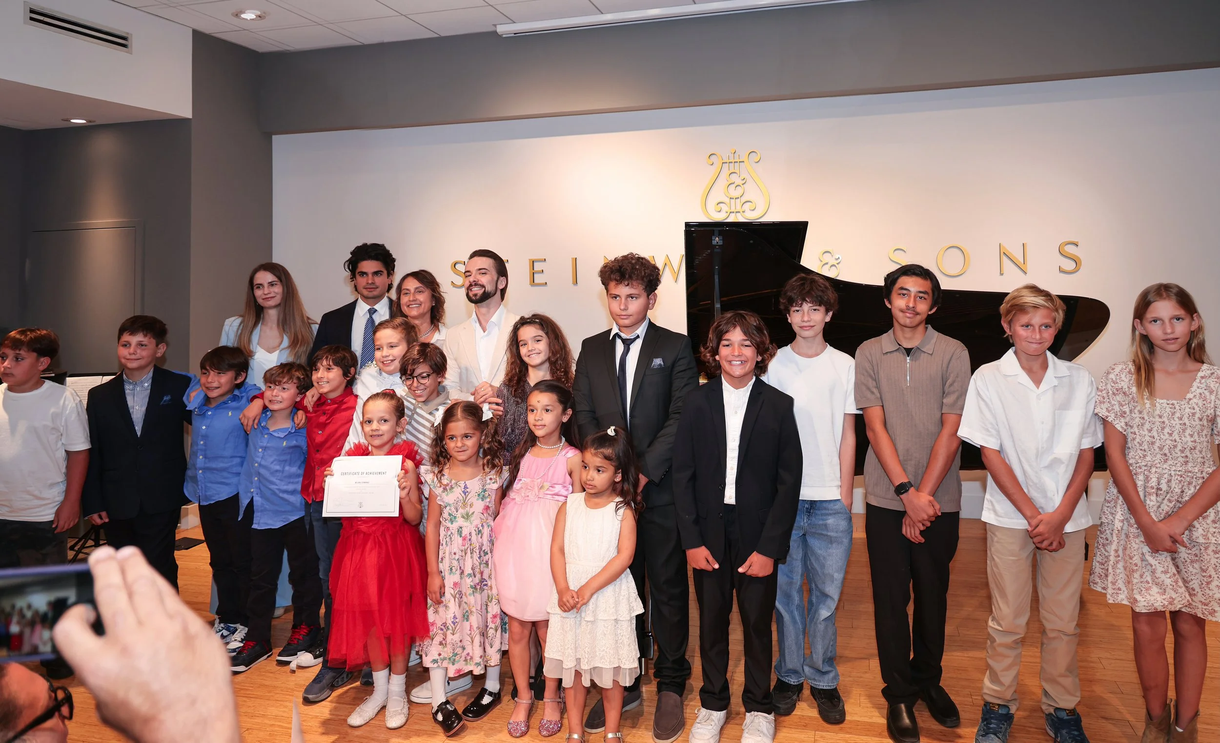 Young piano students and teachers celebrating a student recital at Miami Beach Piano Studio, highlighting musical achievements and performance opportunities for children