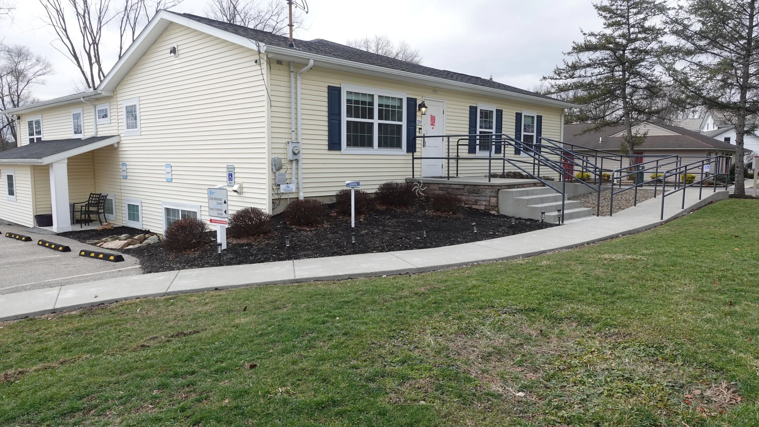 The building that houses The Children's Center of Medina County. It's a light yellow house featuring stairs and a ramp for wheelchair accessibillity.