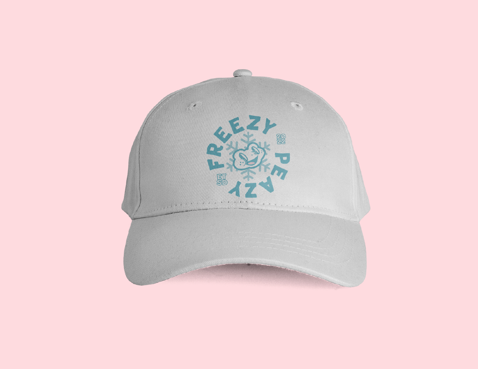 White baseball cap with blue Olaf the snowman graphic and 'FREZZY PEAZ' text on the front, against a pink background.