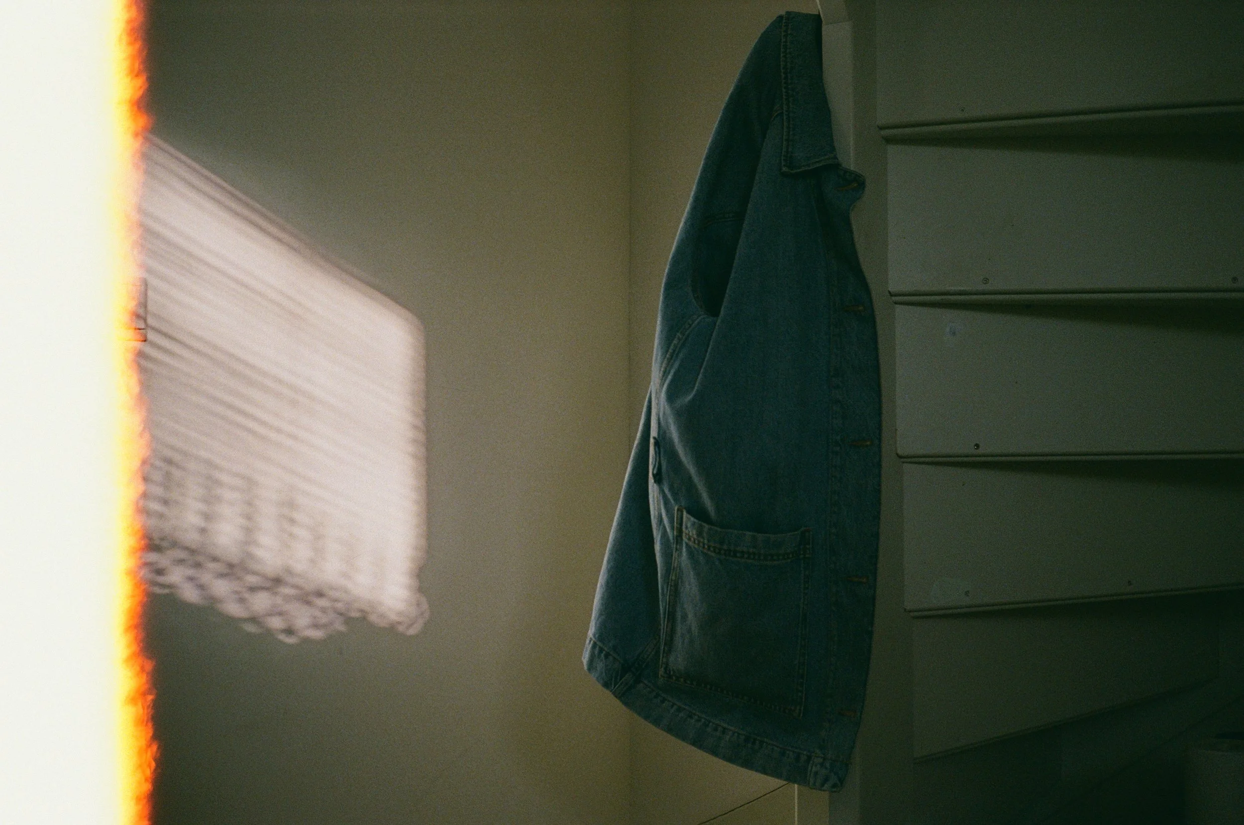 Une veste en jean suspendue à une étagère dans une pièce