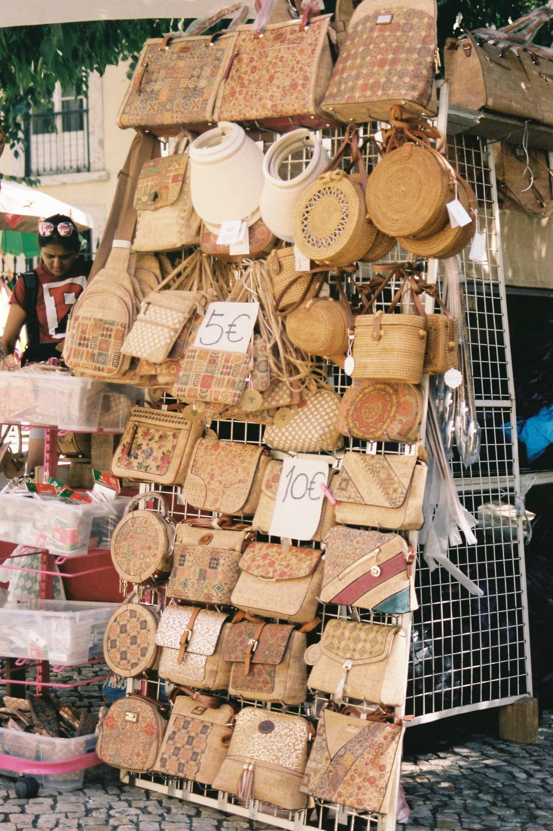 Stand de sacoches en osier et sacs en tissu à la vente dans un marché en plein air.