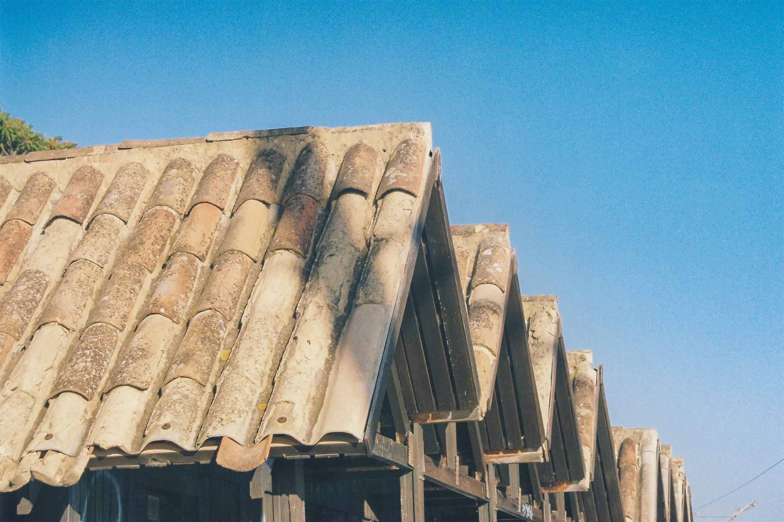 Toit en tuiles en terre cuite contre un ciel bleu.