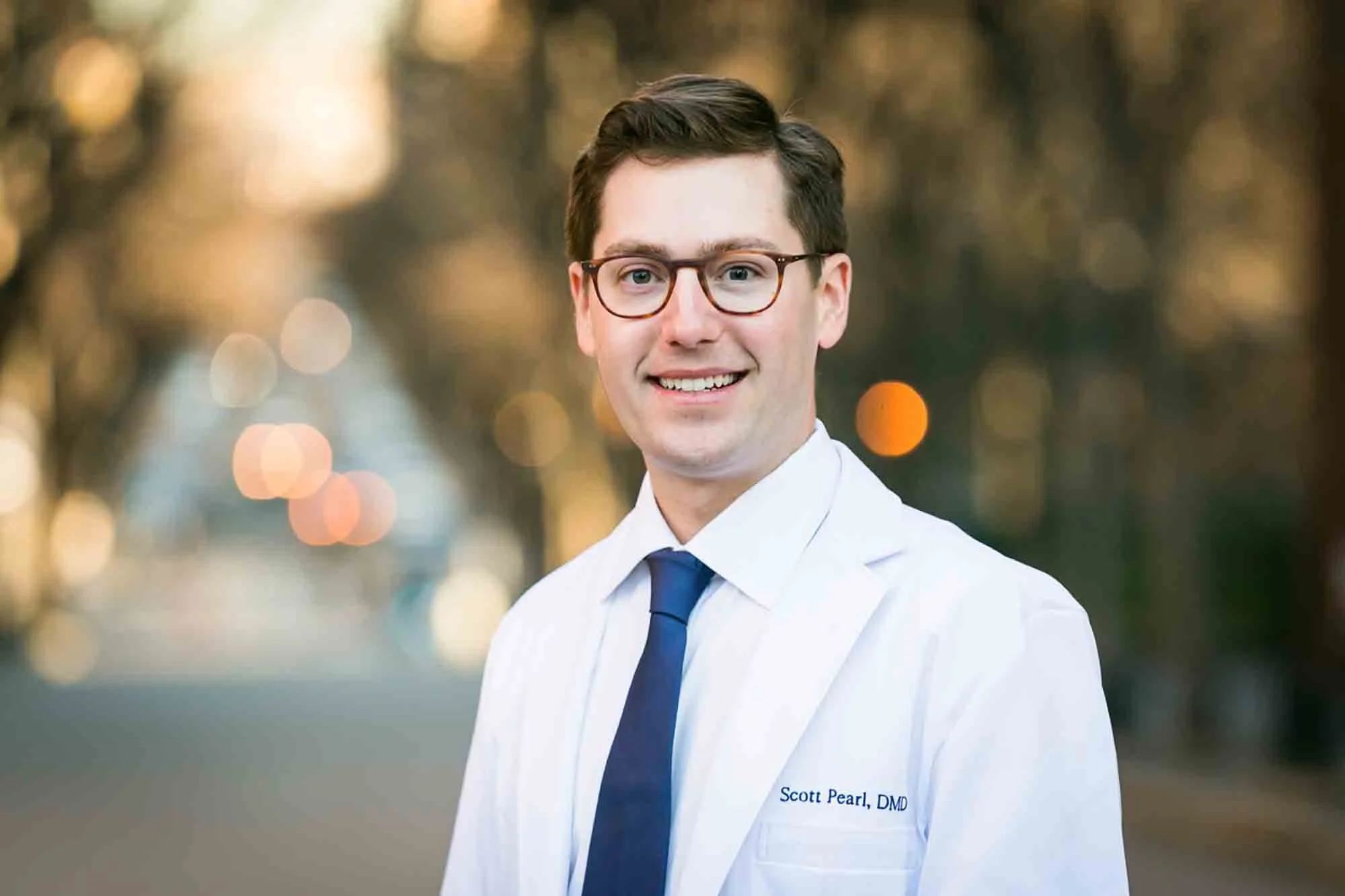 Headshot of doctor wearing white coat and glasses by San Antonio executive headshot photographer, Kelly Williams