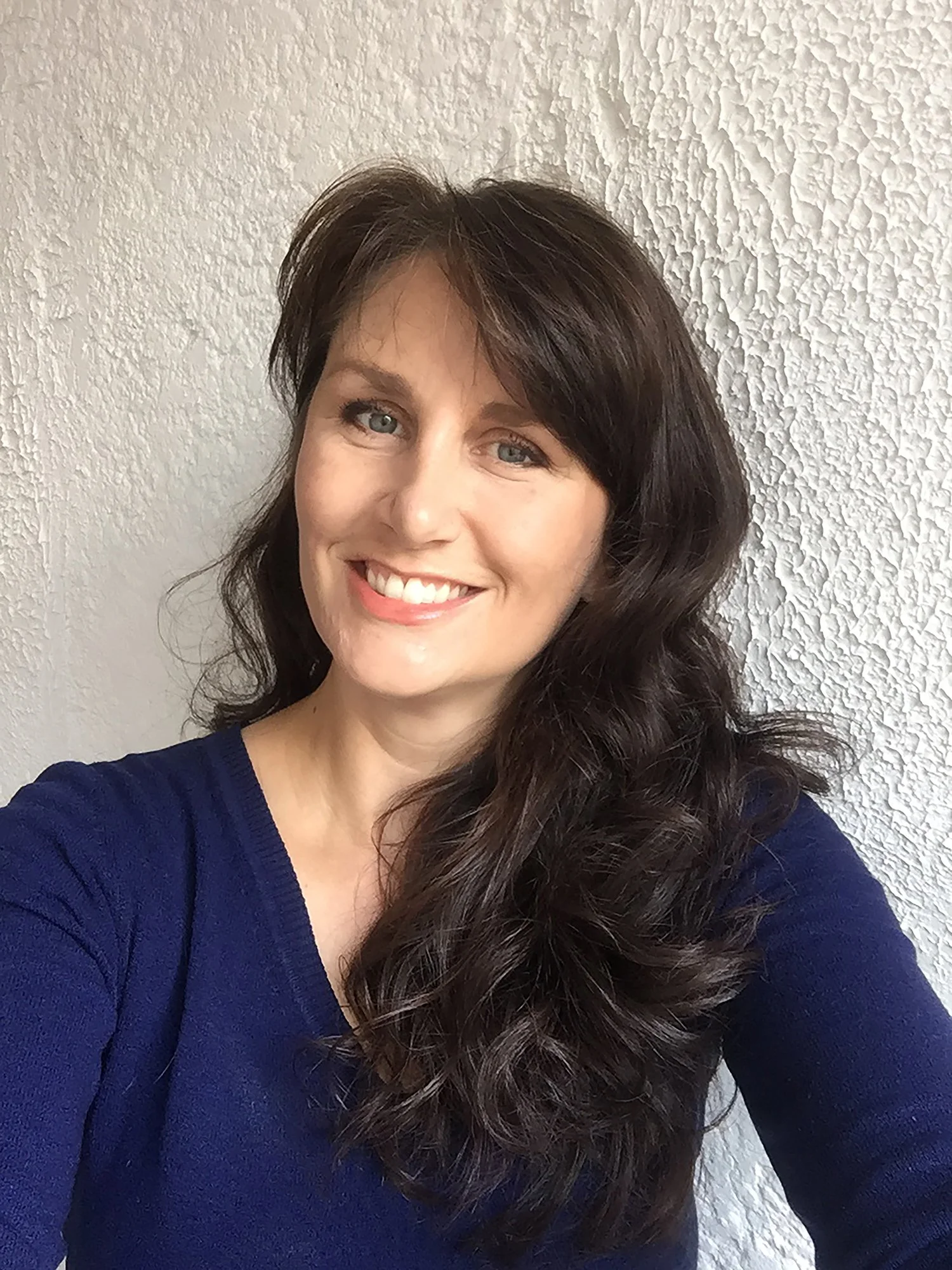 Los Angeles travel photographer and photojournalist, Kelly Williams, wearing a blue sweater