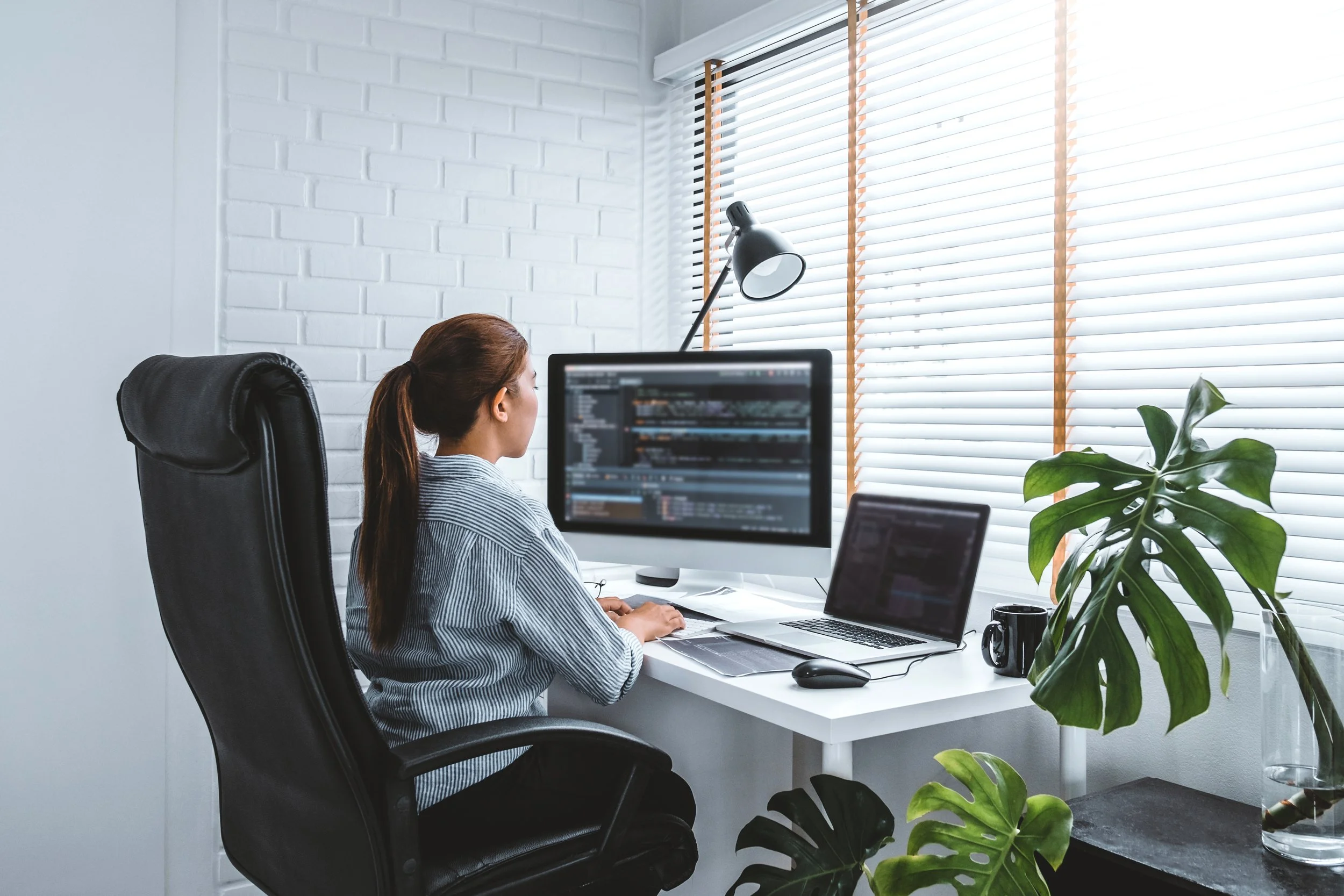 Young woman sitting at an office desk typing