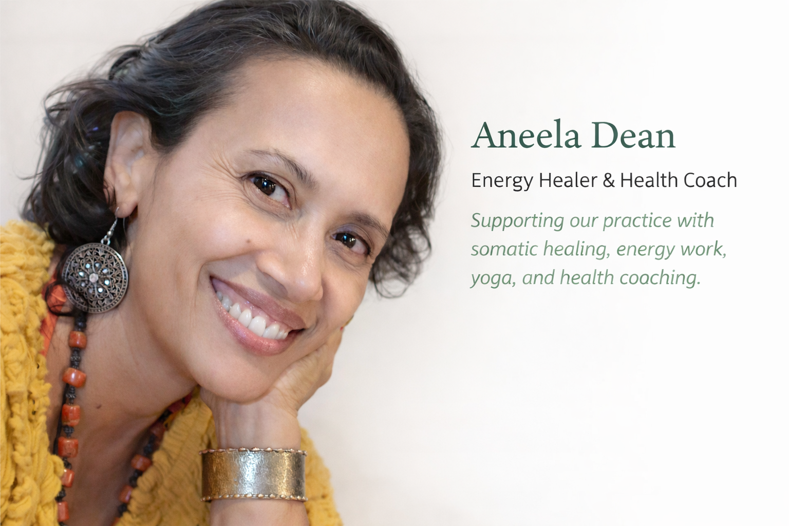Close-up portrait of a smiling woman with curly dark hair, wearing large earrings, a yellow sweater, and a metallic bracelet. To the right, text introduces Aneela Dean, a energy healer and health coach, supporting practice with somatic healing, energy work, yoga, and health coaching.
