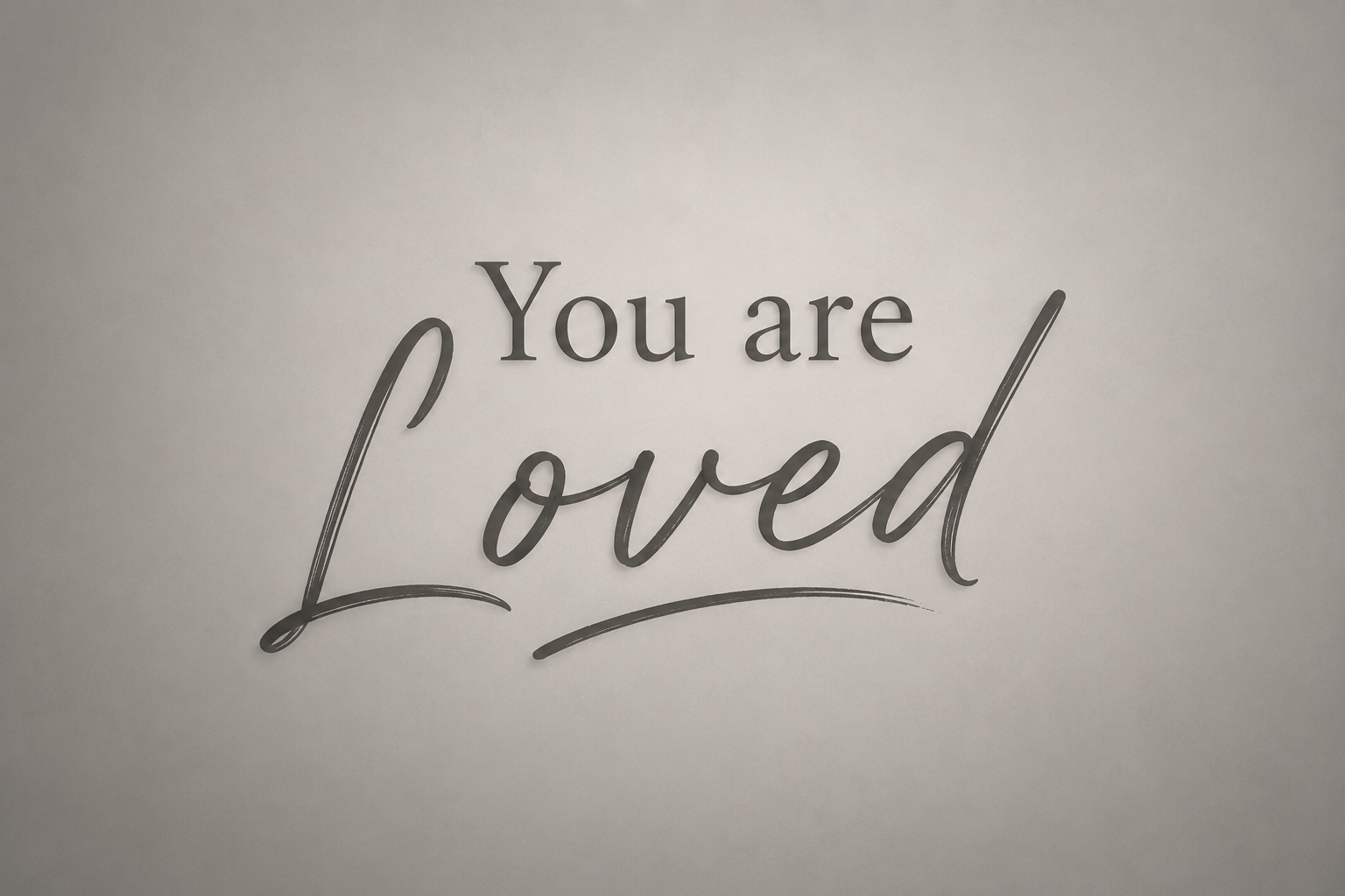 A wall decoration with the words 'You are loved' in black in different fonts.