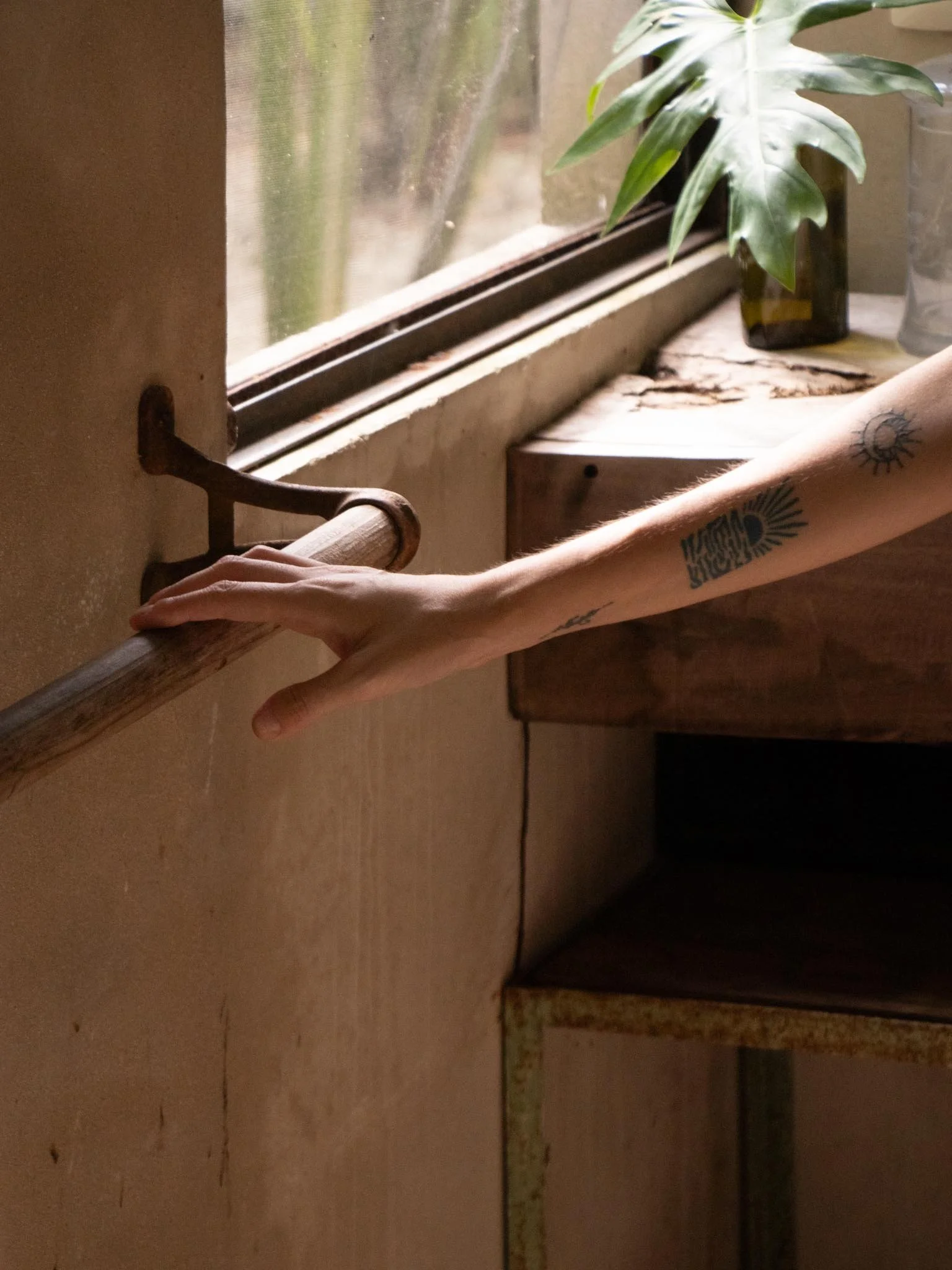 Fotografía con luz natural que expresa soledad introspectiva y apreciación del espacio; un baño rodeado de vegetación tropical que se aprecia por la ventana.