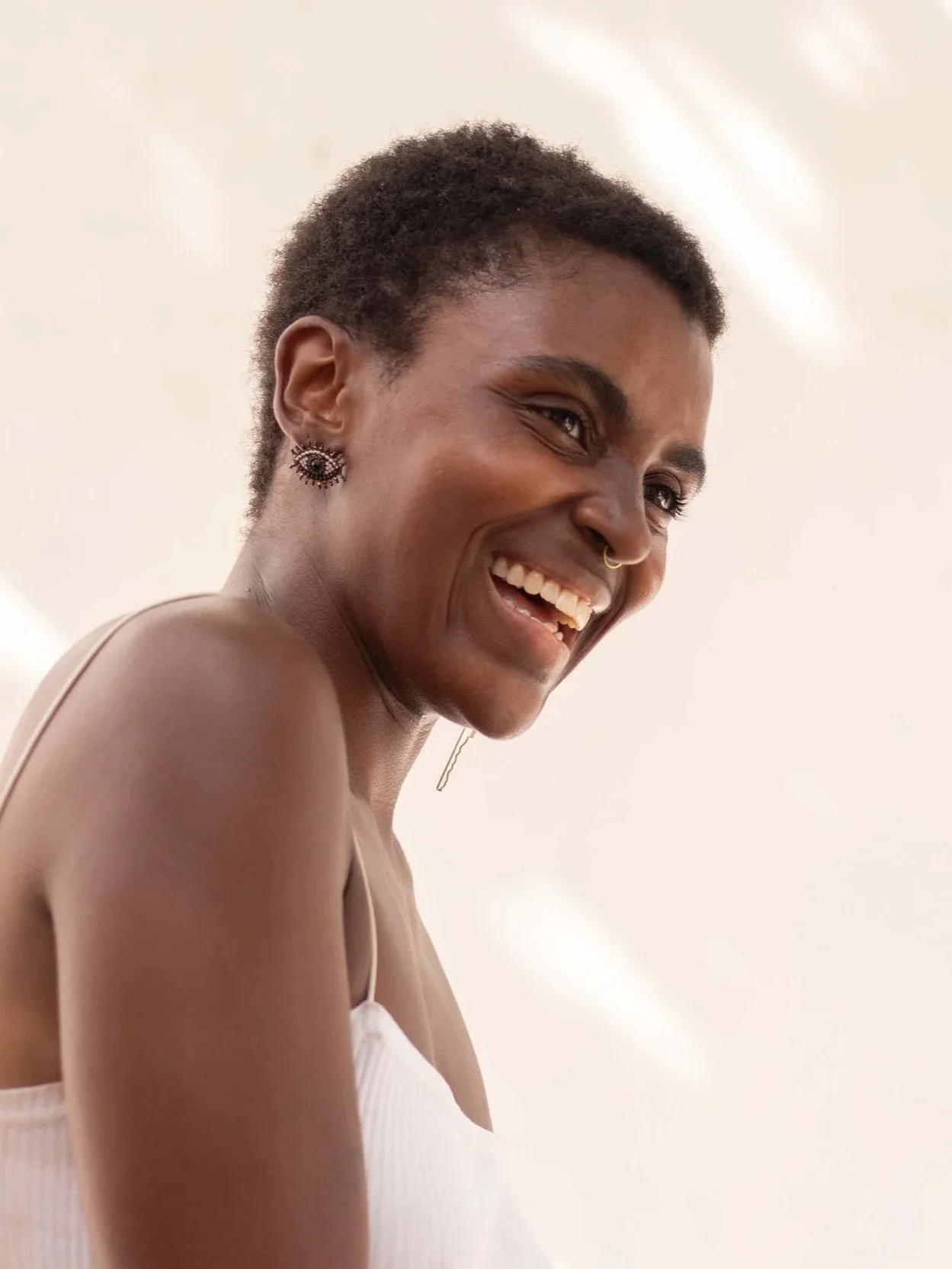 Fotografía de retrato de una joven mujer con gran sonrisa que expresa alegría y amabilidad.