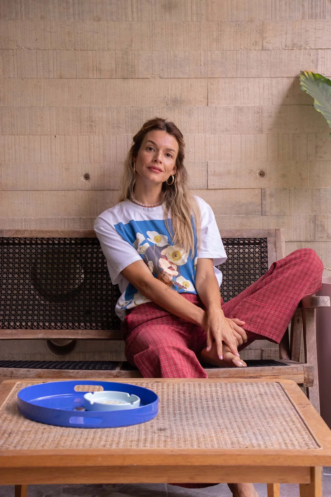 Fotografía editorial de joven mujer sentada con postura relajada y expresión de tranquilidad.