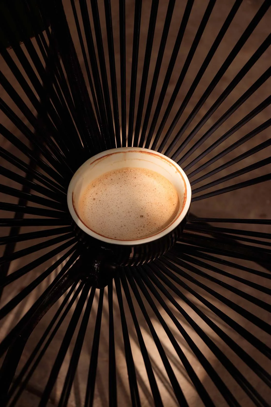 Fotografía de café con leche iluminada con luz natural del medio día que crees sombras y contrastes atractivos.