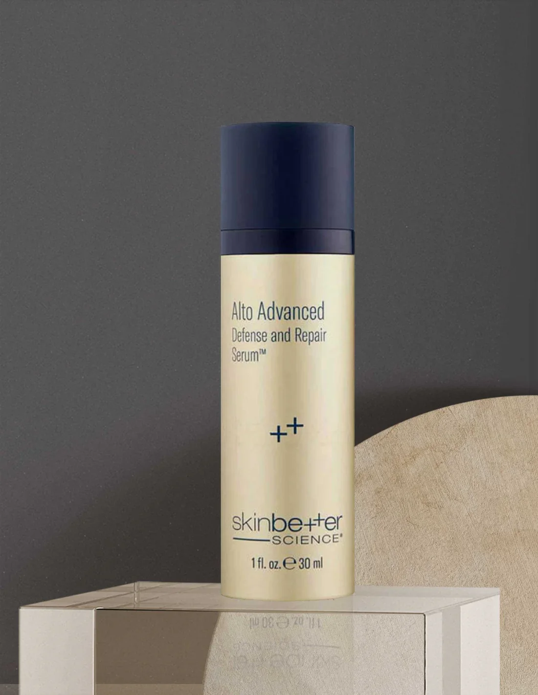 A bottle of Skinbetter Science Alto Advanced Defense and Repair Serum resting on a light-colored surface against a dark background.