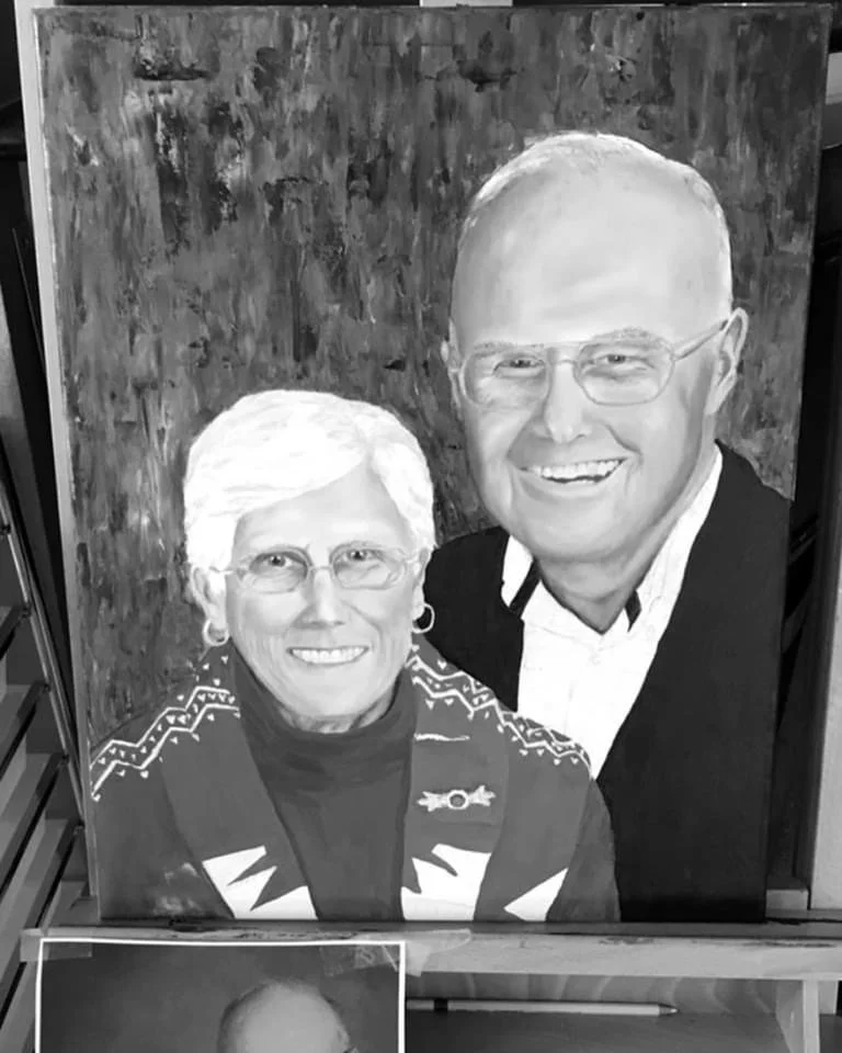 Black and white portrait of an elderly woman and a middle-aged man smiling, with a textured background.