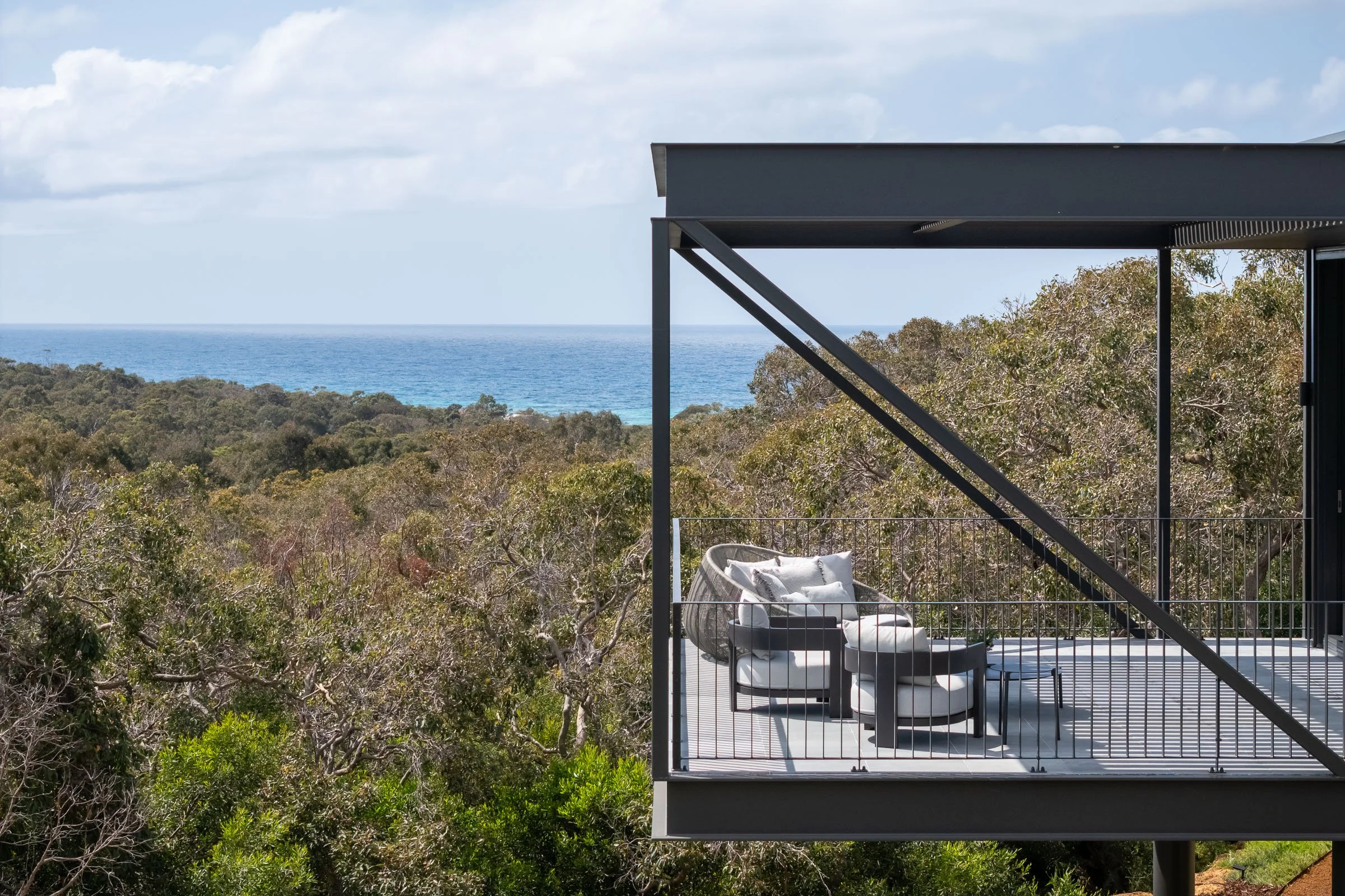 A woman in a long white dress walking through a well-lit arched hallway with wooden doors on either side.