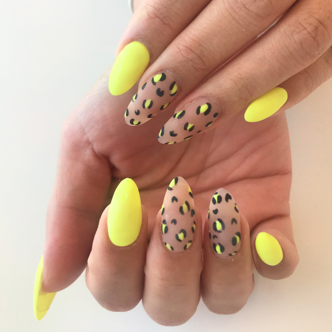 Nail art featuring yellow nails and leopard print design on some nails.
