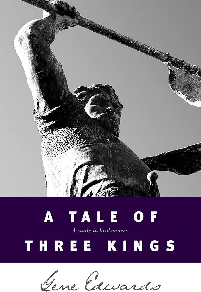Black and white photo of a statue of a person holding a spear or staff, with the head and upper body visible.