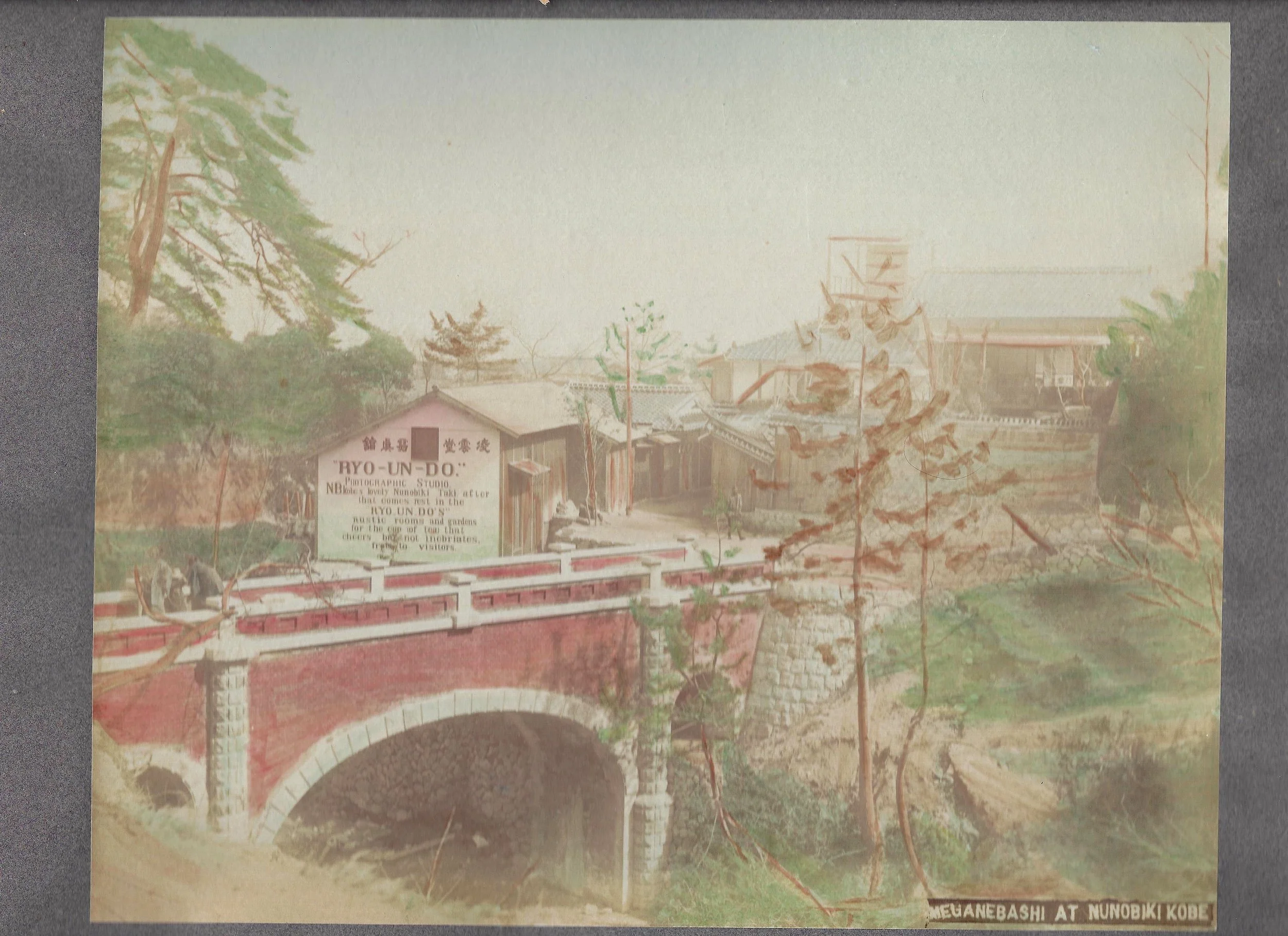 [Hand-colored photograph of the “Ryo-Un-Do” Studio and Meganebashi Bridge].