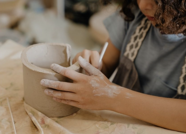 Child working on a pottery piece in a workshop.