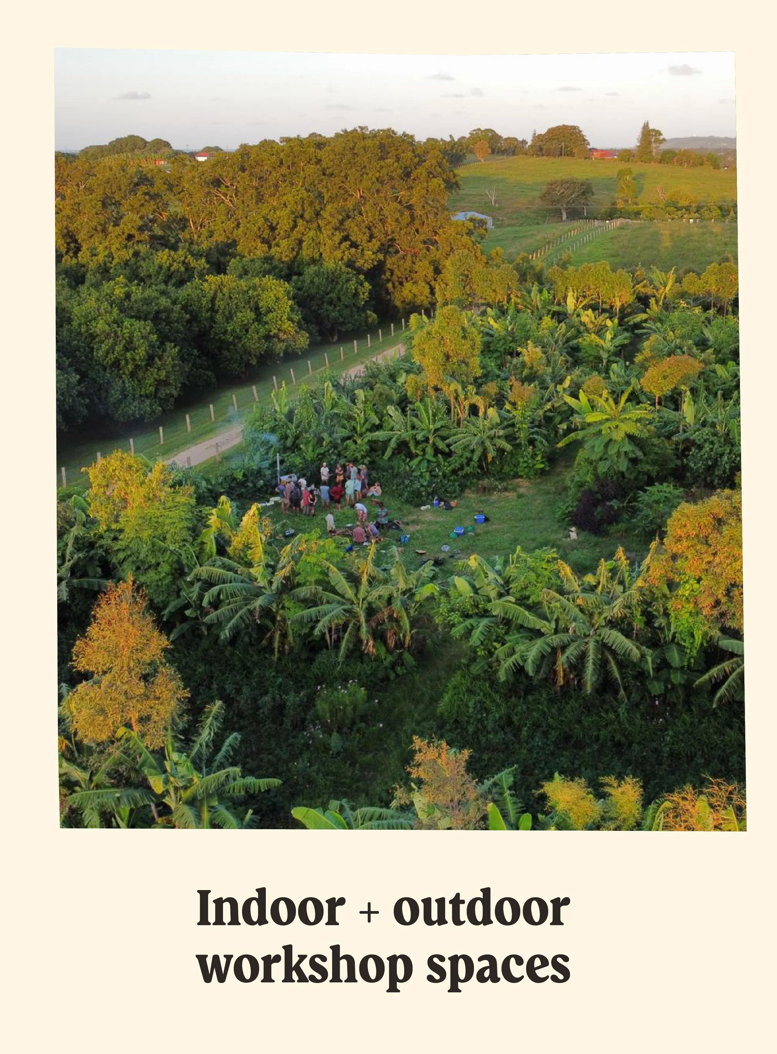 An outdoor workshop space with trees, a group of people gathered, and a scenic landscape with rolling hills and a cloudy sky.
