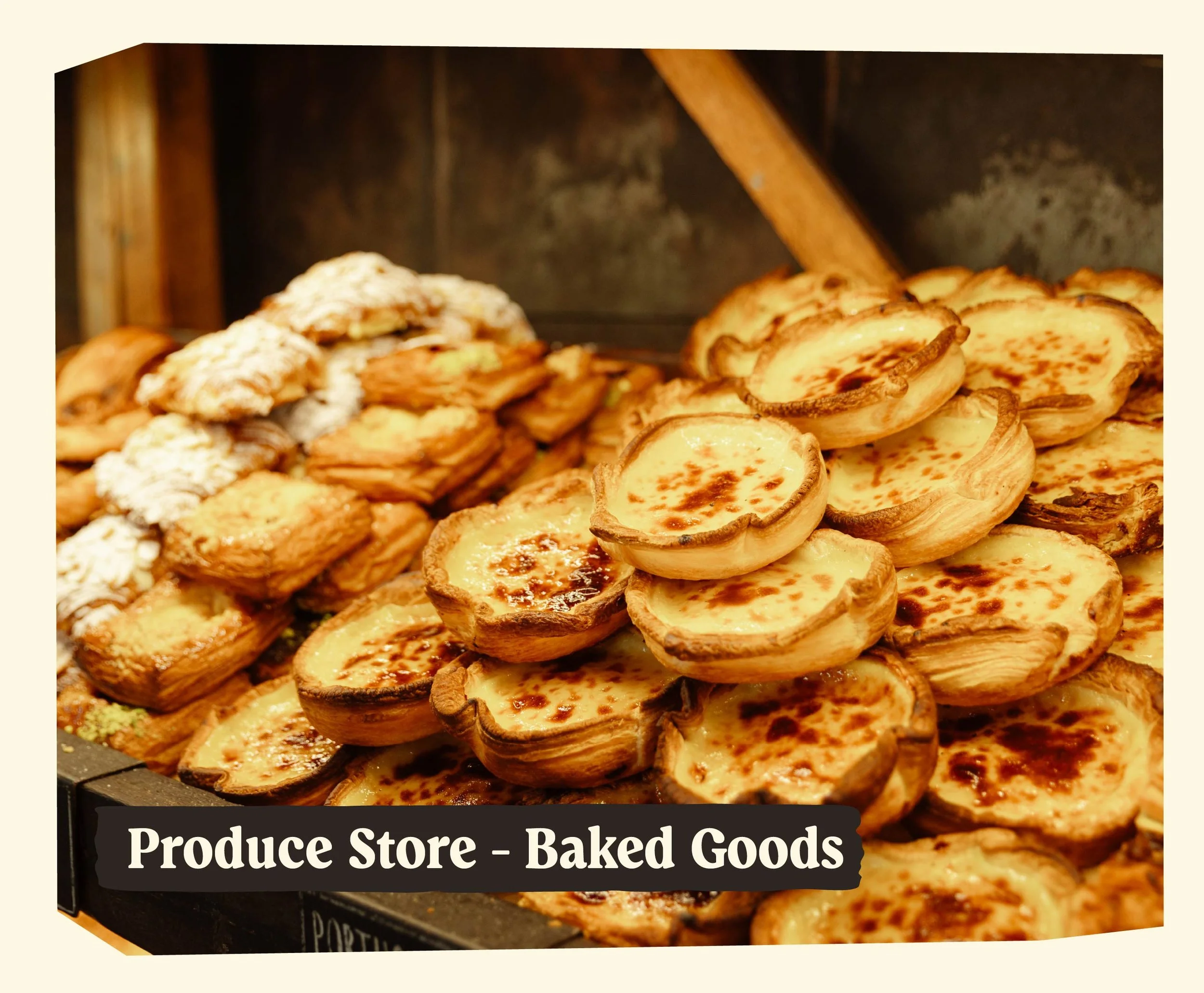 Close-up of baked goods, including small pies with browned tops and pastries dusted with powdered sugar, displayed on a black tray with a sign reading 'Produce Store - Baked Goods'.