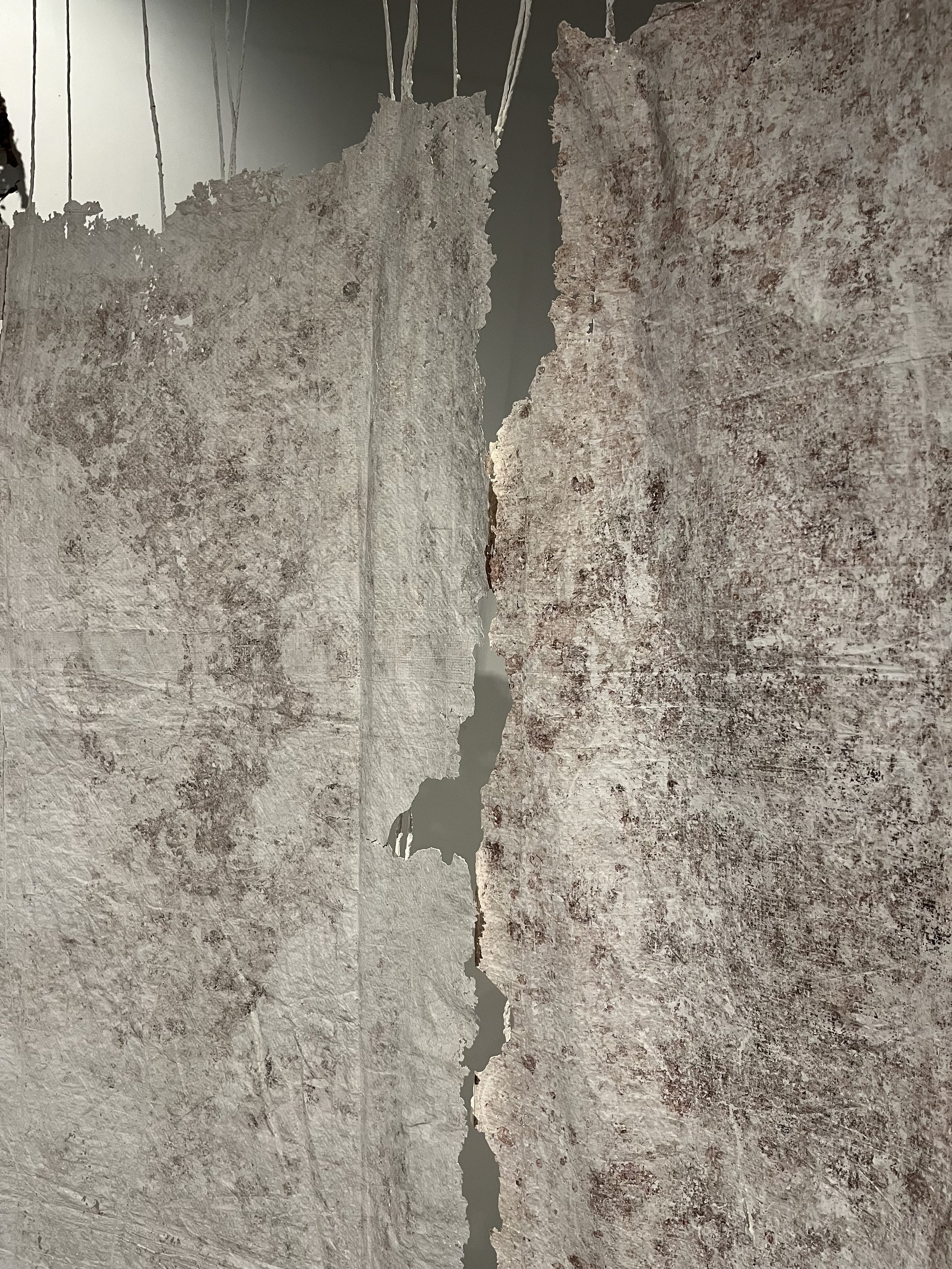 Close-up of a cracked or broken marble or stone surface with rough edges and a visible crack.