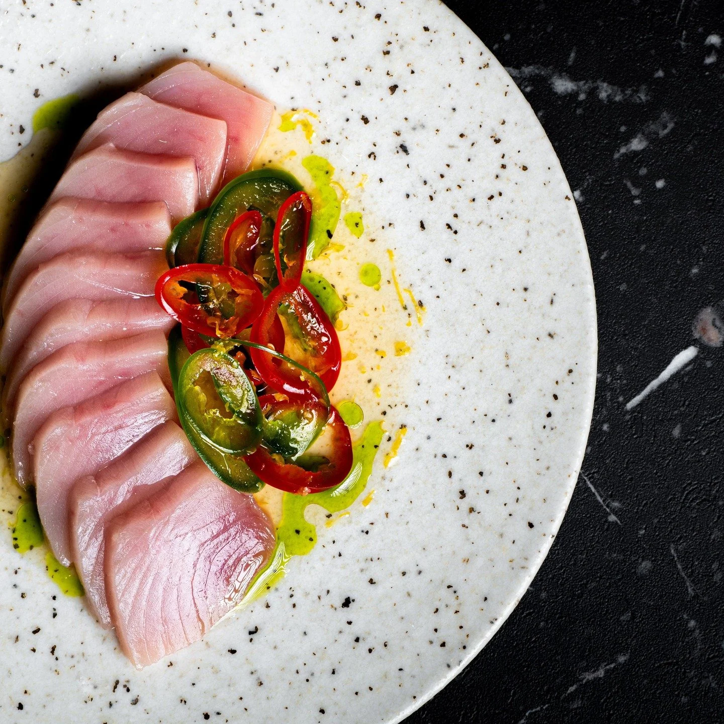 Our take on a sushi classic The Pepperfin.
Local Shiro maguro sliced to melt in your mouth, set onto a citrus-driven Shiro-dashi citronette, finished with aromatic sesame, shiso oil and delicately compressed chilis. Heat, acidity, and umami in perfec