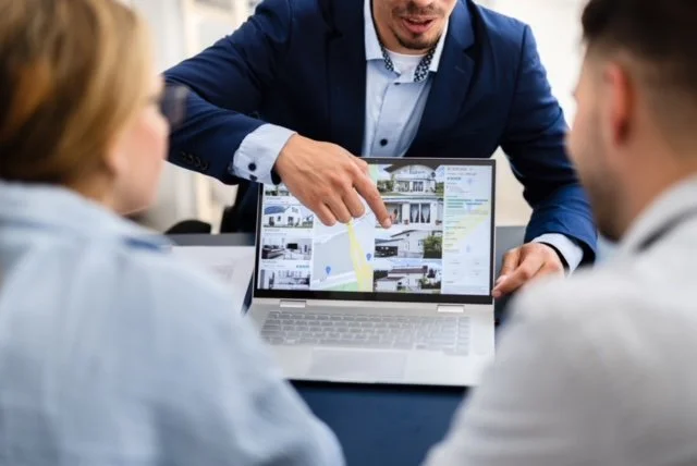 Agent showing property options to Happy Couple