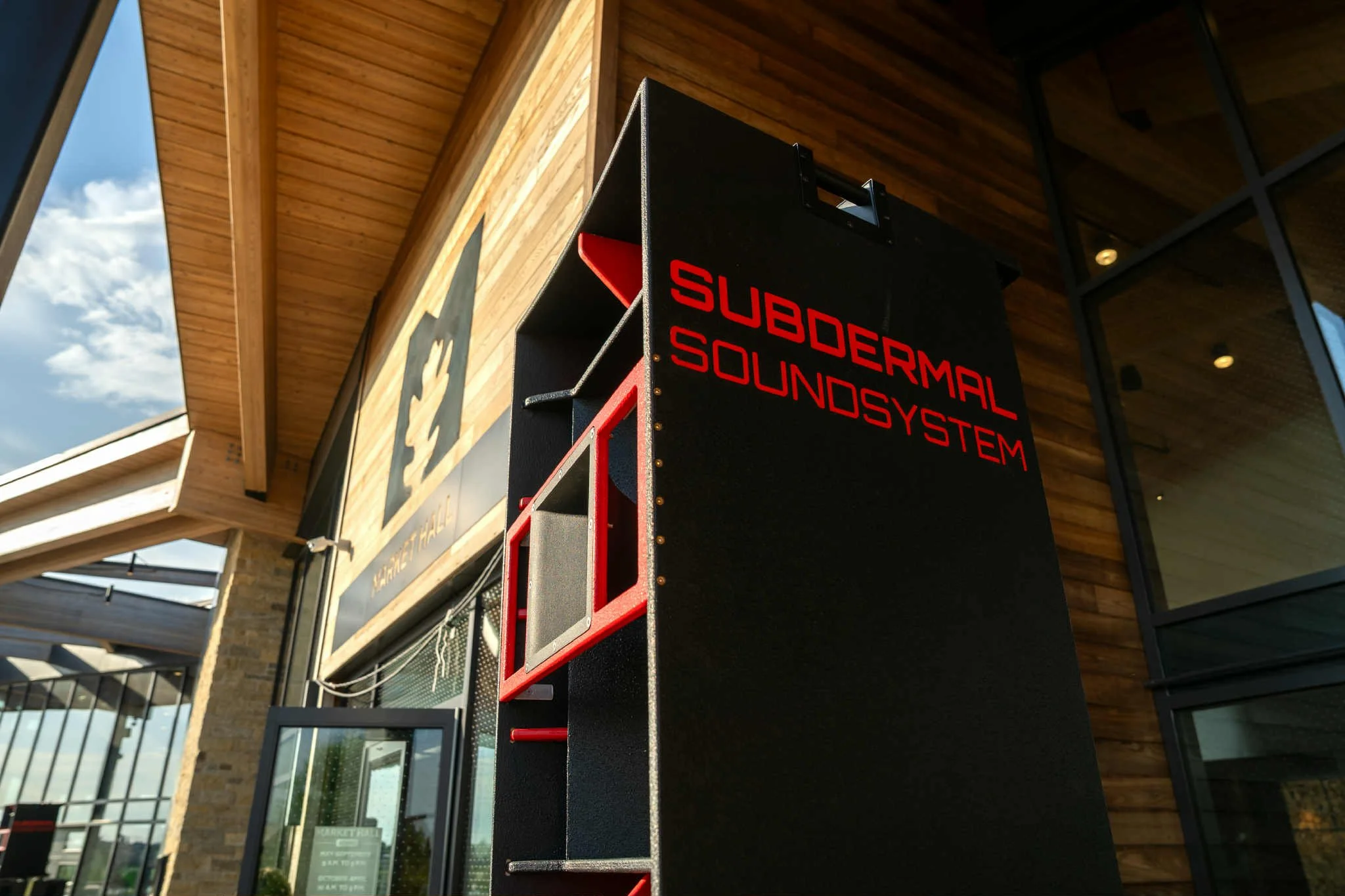 Scenic landscape with a large lake, green hills, and mountains in the background under a cloudy sky.