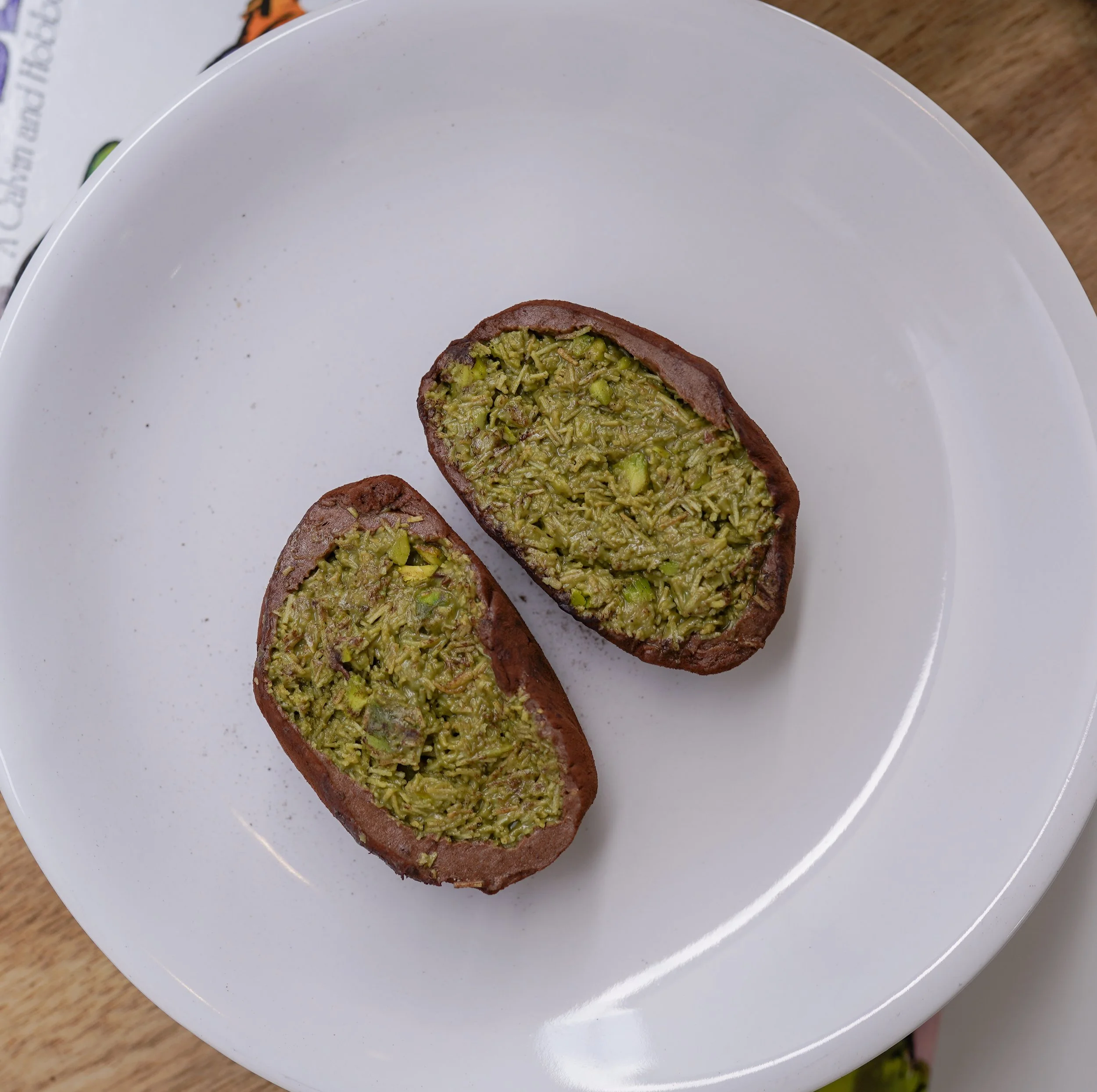 Pistachio filled chocolate cookies on a white plate