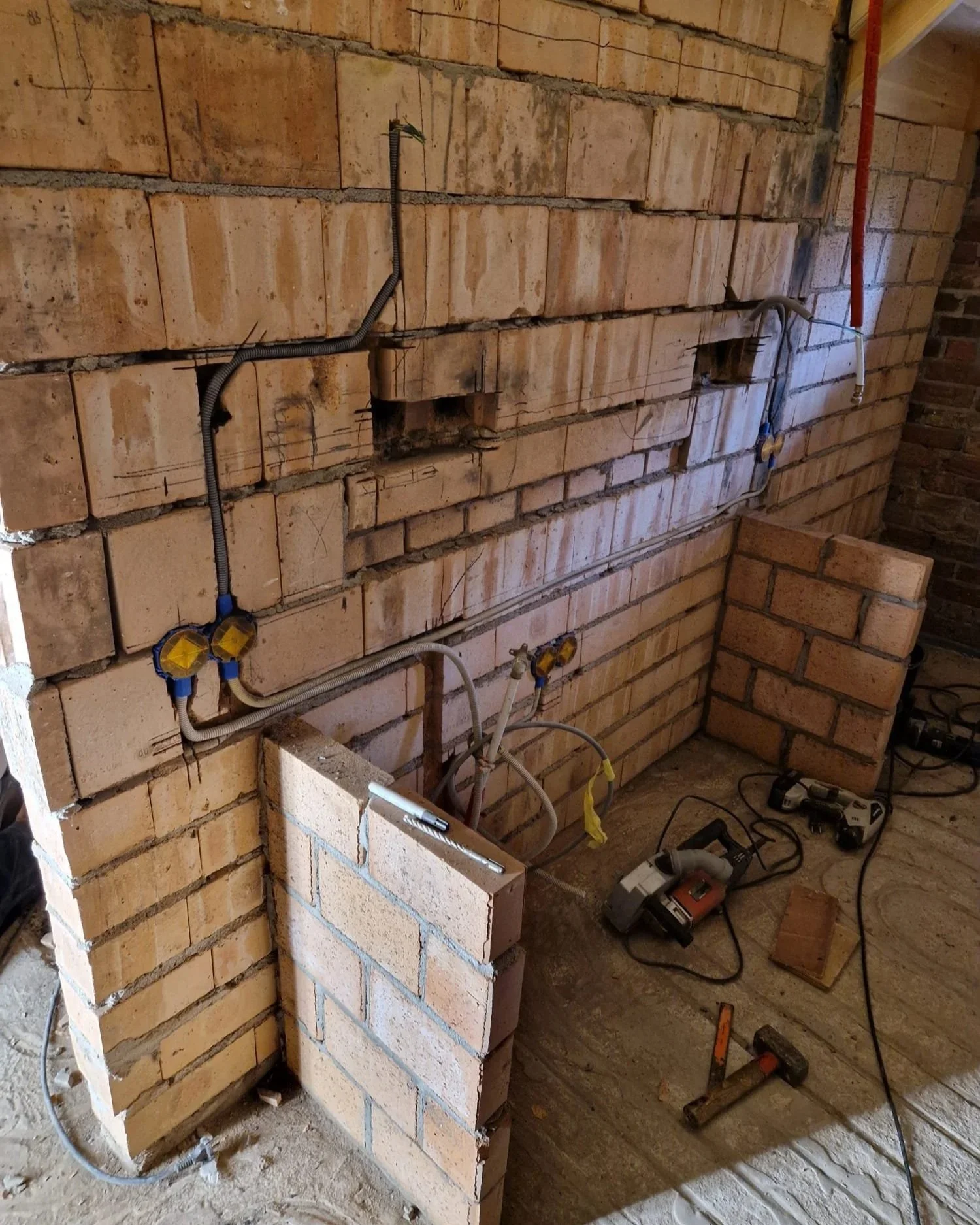 Een bouwplaats met bakstenen muren en elektrisch gereedschap, klaar voor verdere constructiewerkzaamheden.