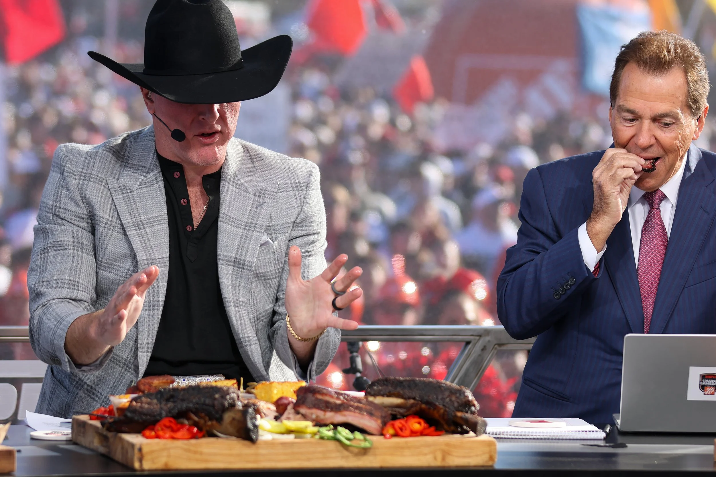 ESPN College GameDay analysts Pat McAfee and Nick Saban eat BBQ brisket for Evie Mae's during the show's live broadcast on the Texas Tech University campus on Nov. 8, 2025 in Lubbock, Texas.