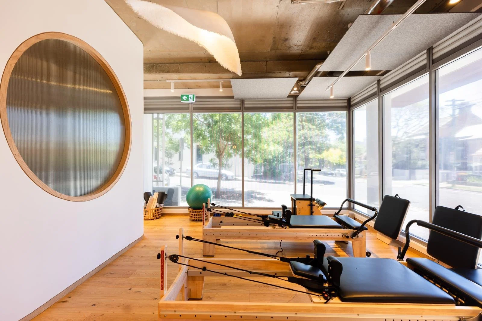 Pilates or physical therapy studio with reformer machines, exercise ball