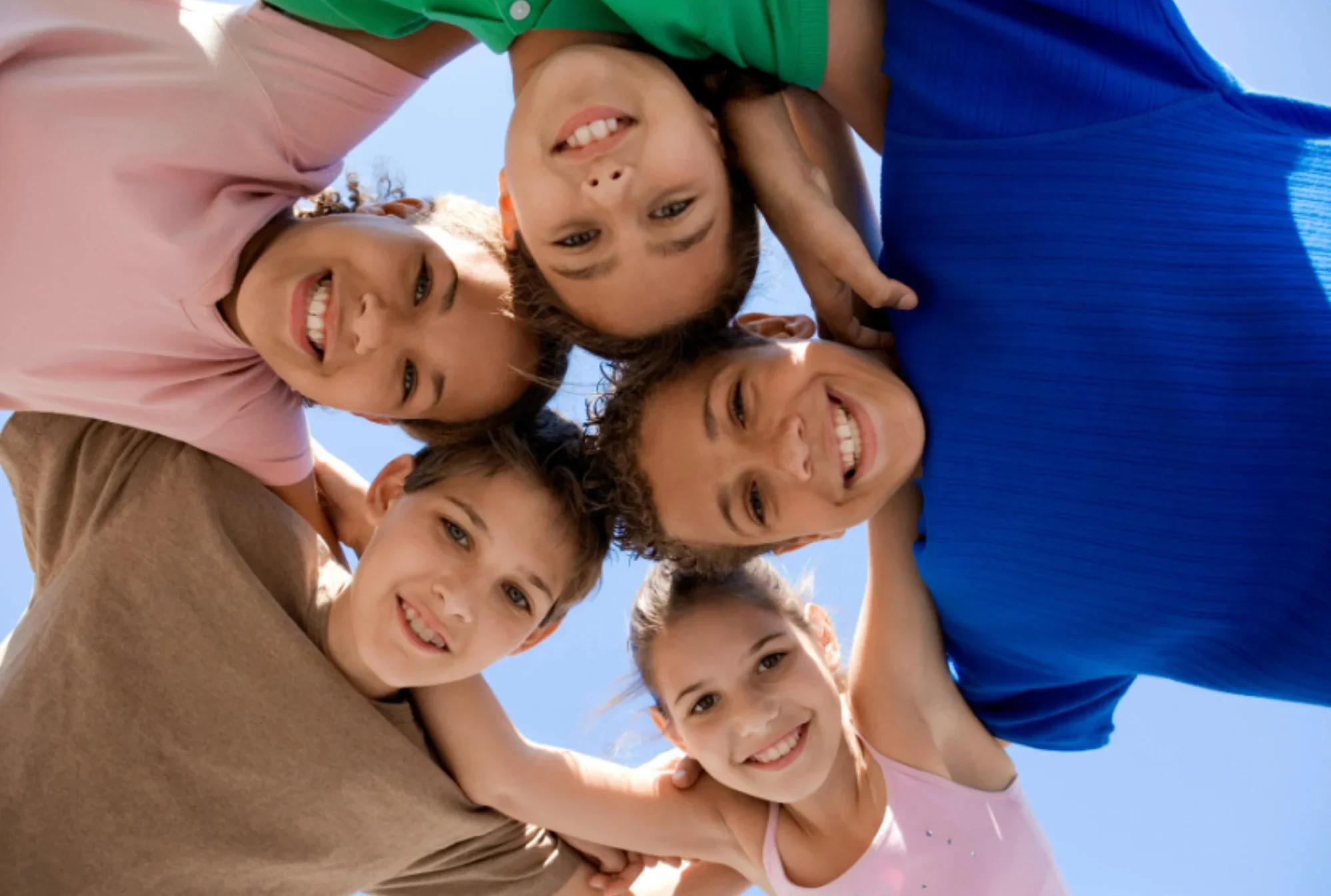 Children, teens smiling, huddled together in a circle outdoors after speech therapy, social skills group for teens with ADHD and social skills training for teens with autism near Cherry Hill, Evesham, Mt. Laurel, and Moorestown, NJ in South Jersey.