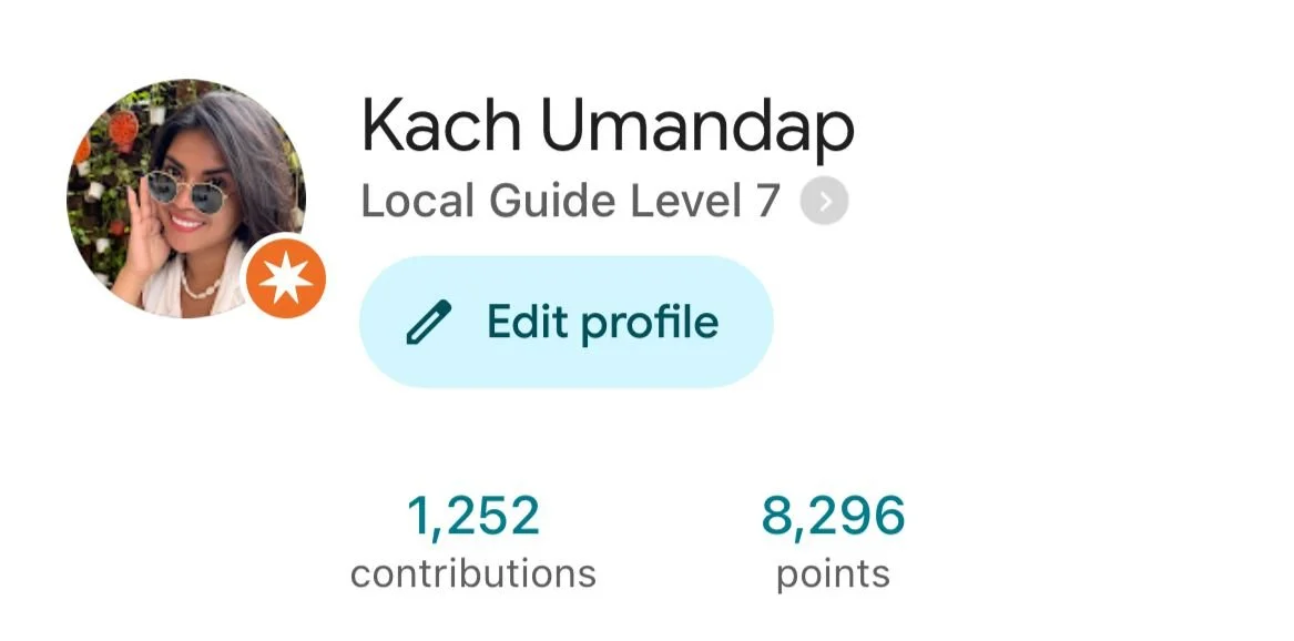 Profile page for Kach Umandap showing a circular profile picture of a woman wearing sunglasses and smiling, with a background of flowers, and profile details including level 7 local guide, the name, an edit profile button, contributions count of 1,252, and total points of 8,296.