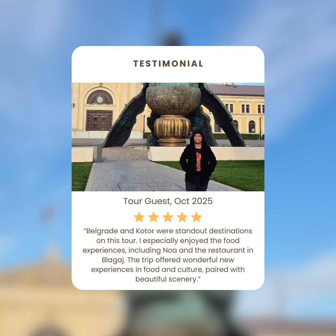 Tourist standing in front of a large sculpture at a historical building with a yellow facade in Belgrade