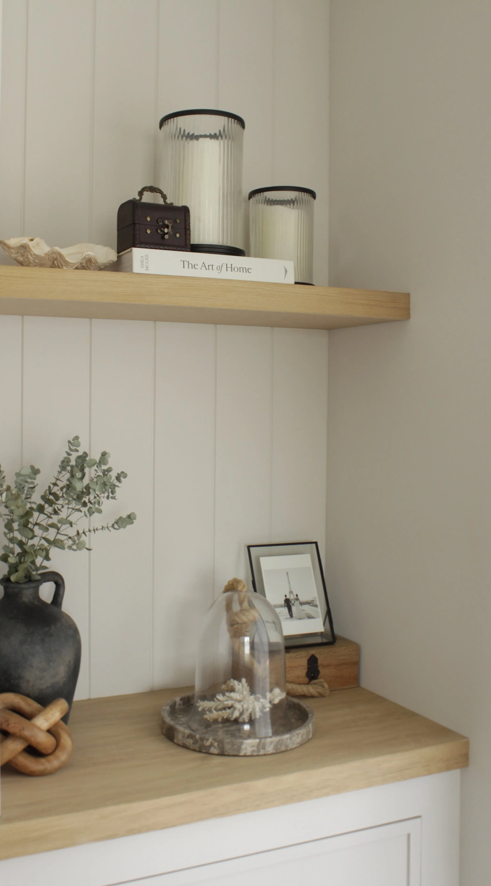 Oak display shelving with decorative styling integrated into a bespoke modern farmhouse fireplace wall.