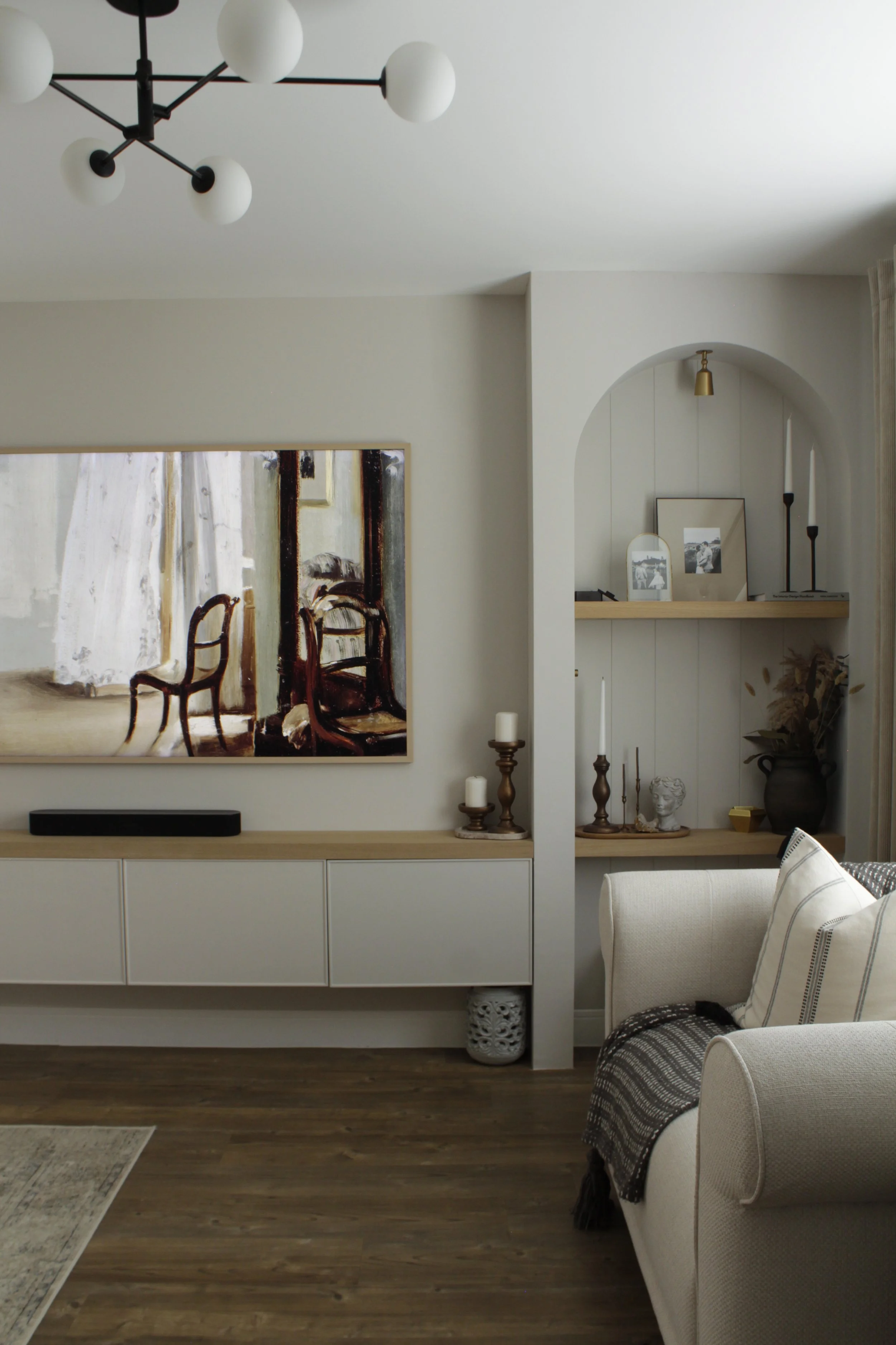 Bespoke media wall with arched shelving, oak details and integrated storage in a modern farmhouse living room.