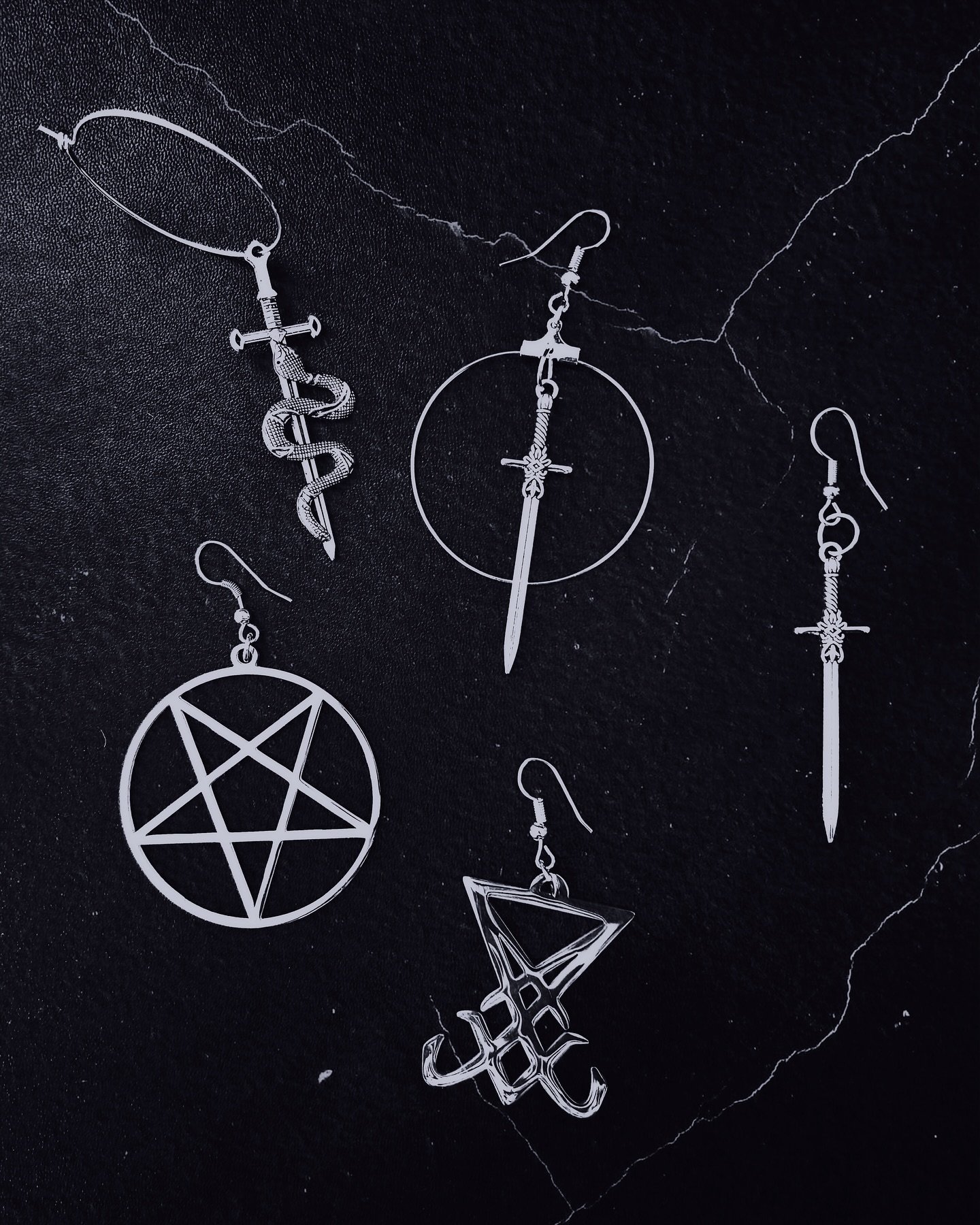 Blades, sigils, and symbols &ndash; earrings that slipped into the shadows while the rest of the collection took the stage. Time to let them speak for themselves. Five symbols, five paths. Which one calls to you?

___

#nightboundcreations #metalfash