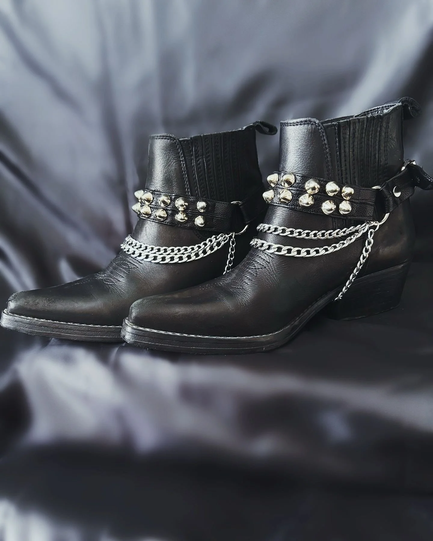 Add a rebellious edge to your footwear with this high-gloss, cruelty-free band. Detailed with bold metallic etchings and linked accents, it brings a gritty flair to any look.