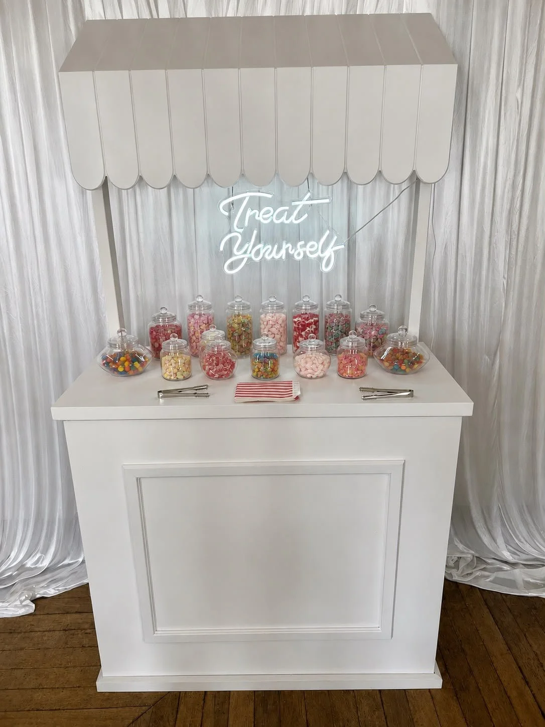 Sweet Stall with jars of sweets, illuminated Neon sign and with tongs and sweet bags