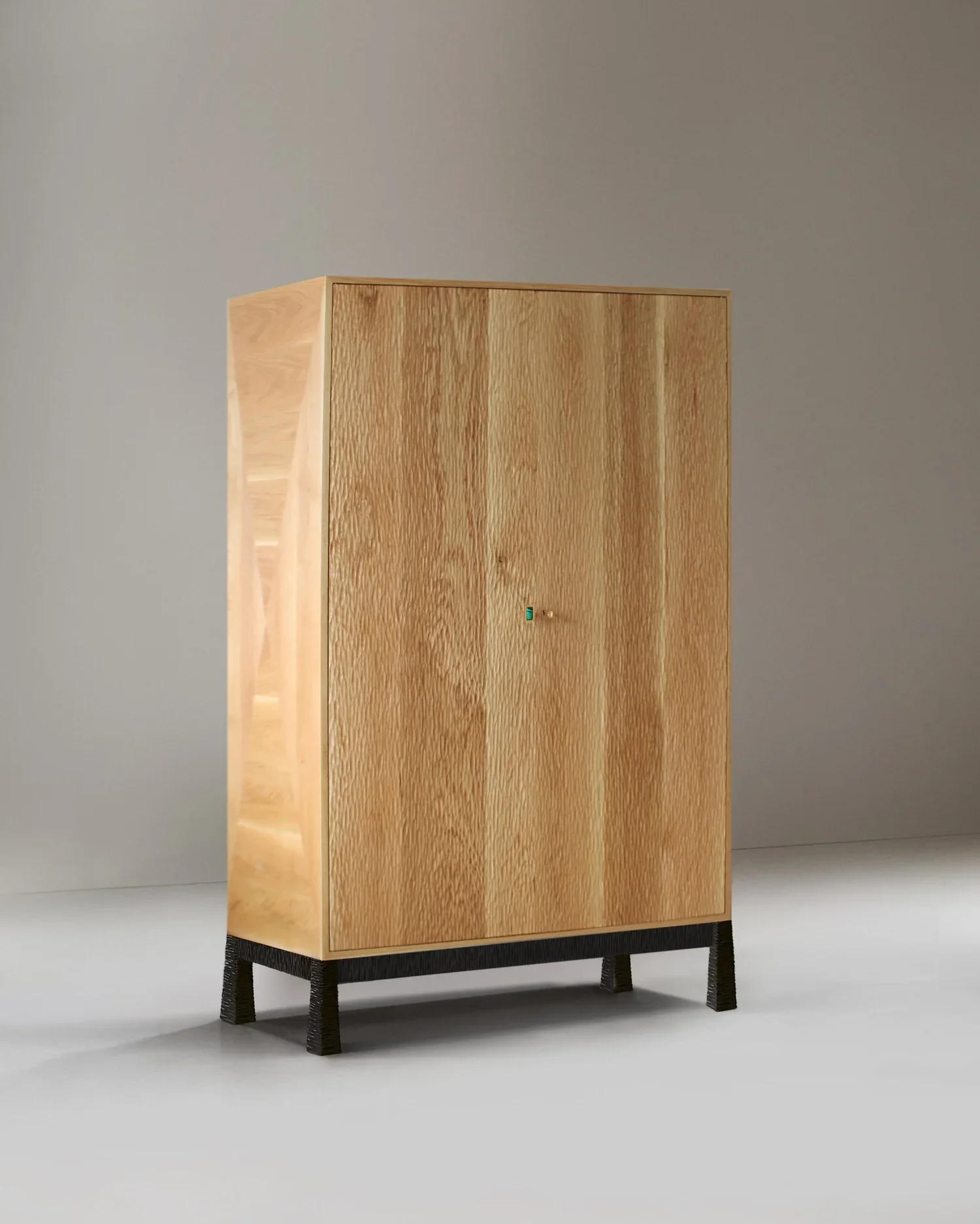 Móvel em carvalho escavado maciço, com pernas em latão negro e prateleiras interiores ajustáveis em carvalho