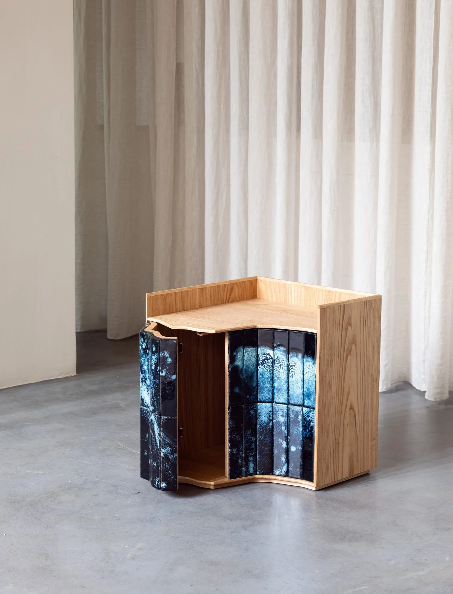 Mesa de cabeceira em castanho português maciço, com portas revestidas a azulejo.