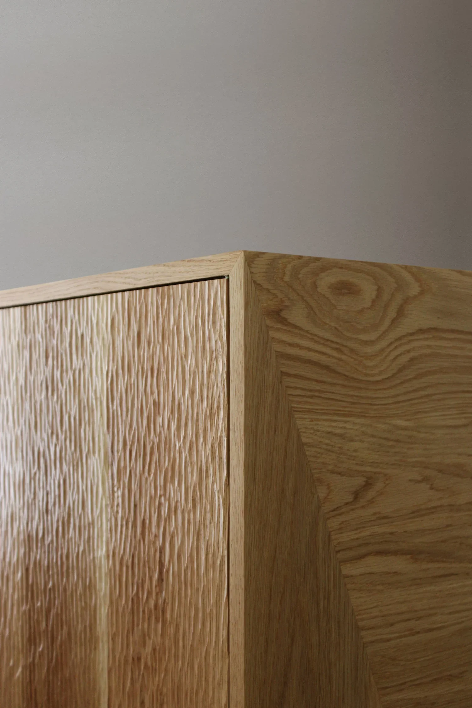 Móvel em carvalho escavado maciço, com pernas em latão negro e prateleiras interiores ajustáveis em carvalho