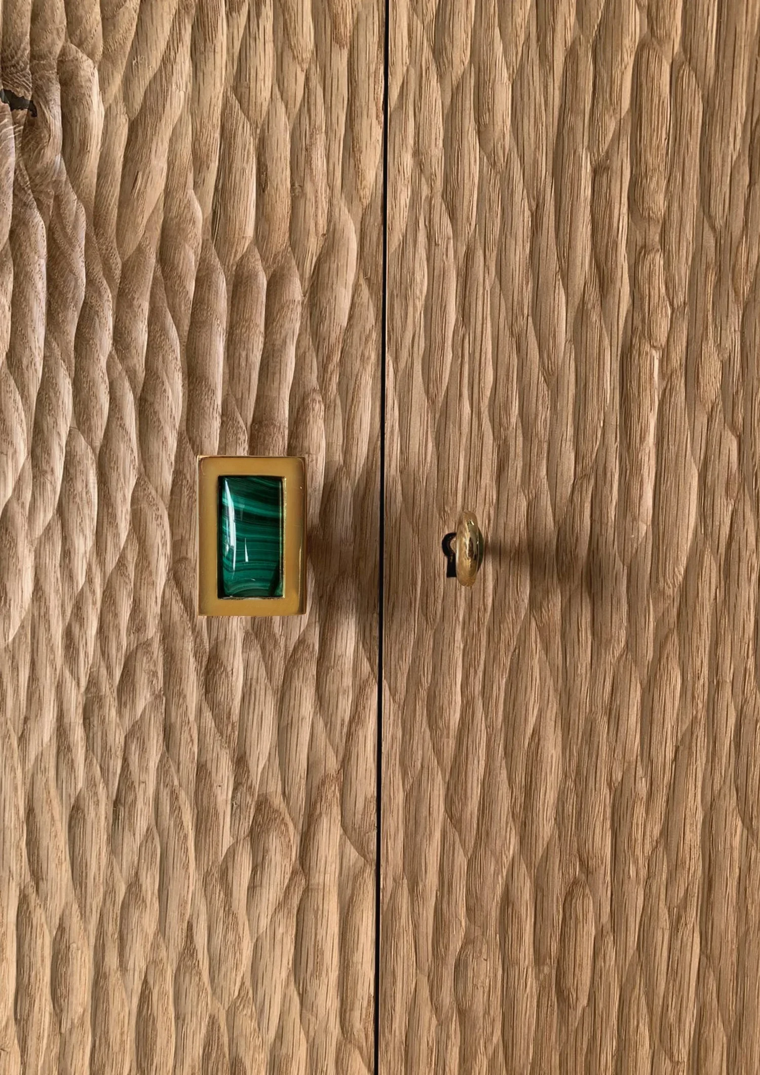 Móvel em carvalho escavado maciço, com pernas em latão negro e prateleiras interiores ajustáveis em carvalho