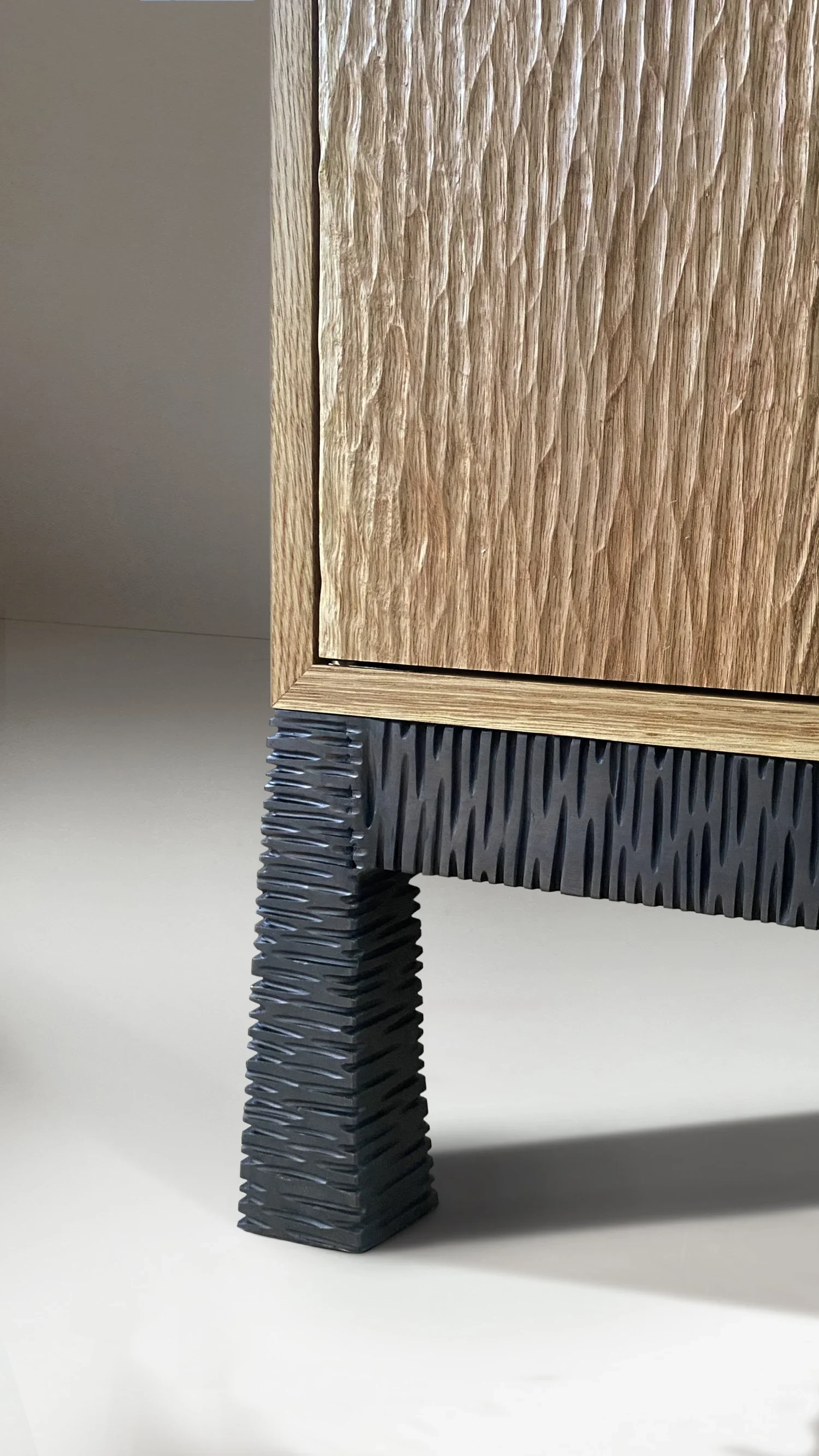 Móvel em carvalho escavado maciço, com pernas em latão negro e prateleiras interiores ajustáveis em carvalho