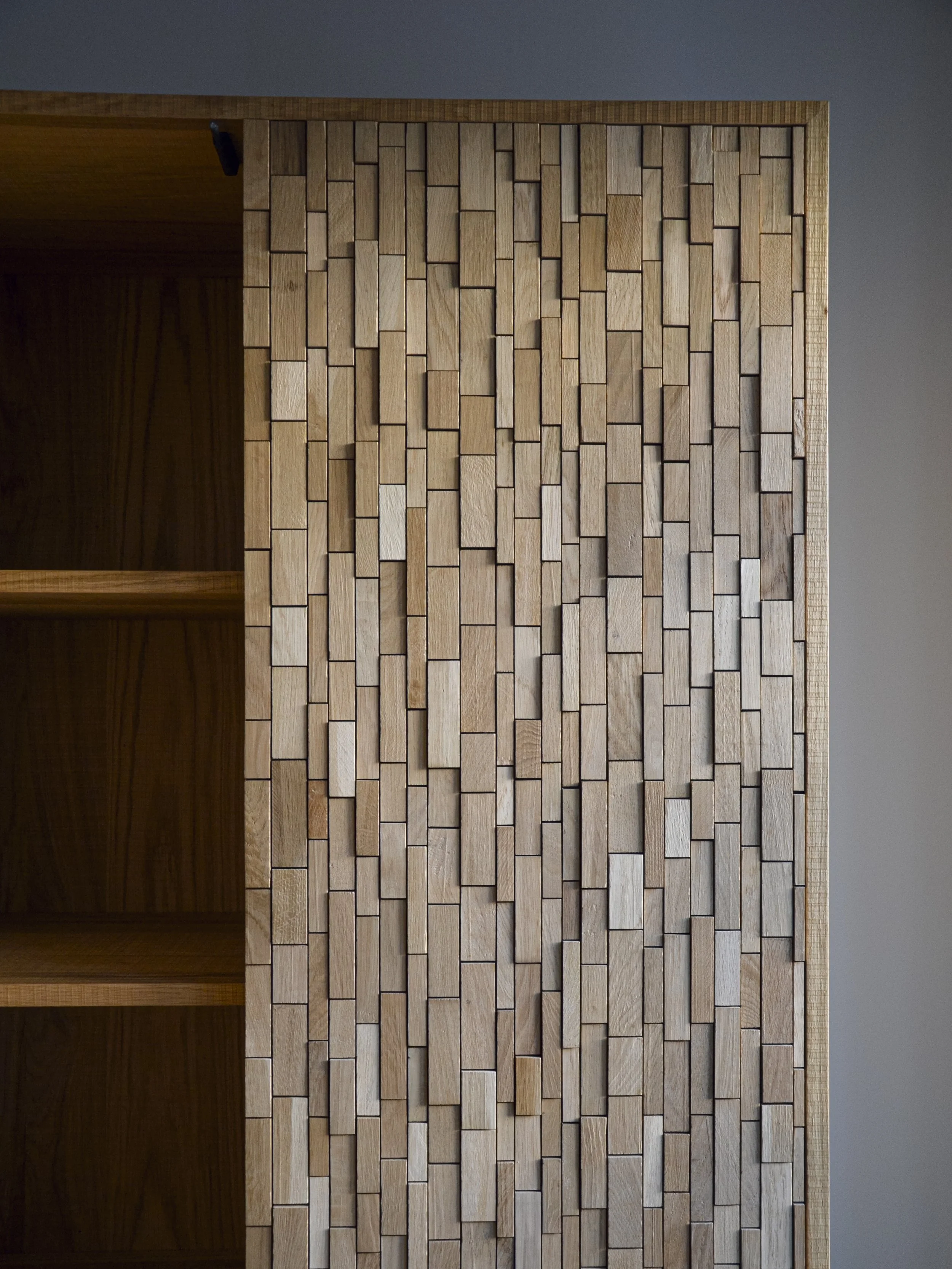 Móvel louceiro folheado a carvalho com efeito de serra, portas revestidas com mosaicos em carvalho e base em ferro lacado a preto mate.